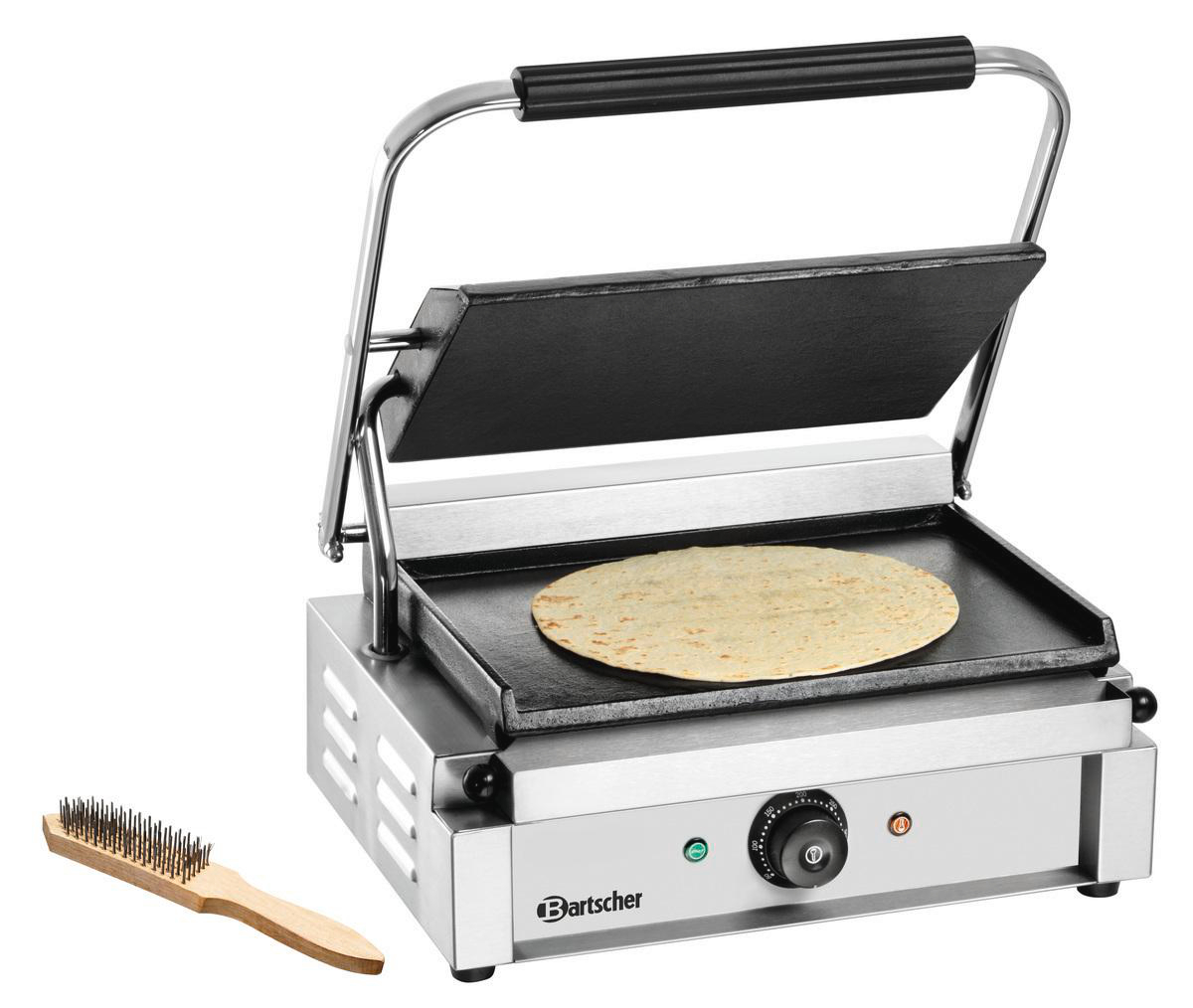 Ein kommerzieller Panini-Grill mit einer runden Tortilla auf der Platte. Neben der Presse befindet sich eine Bürste. Die Presse ist aus Edelstahl.