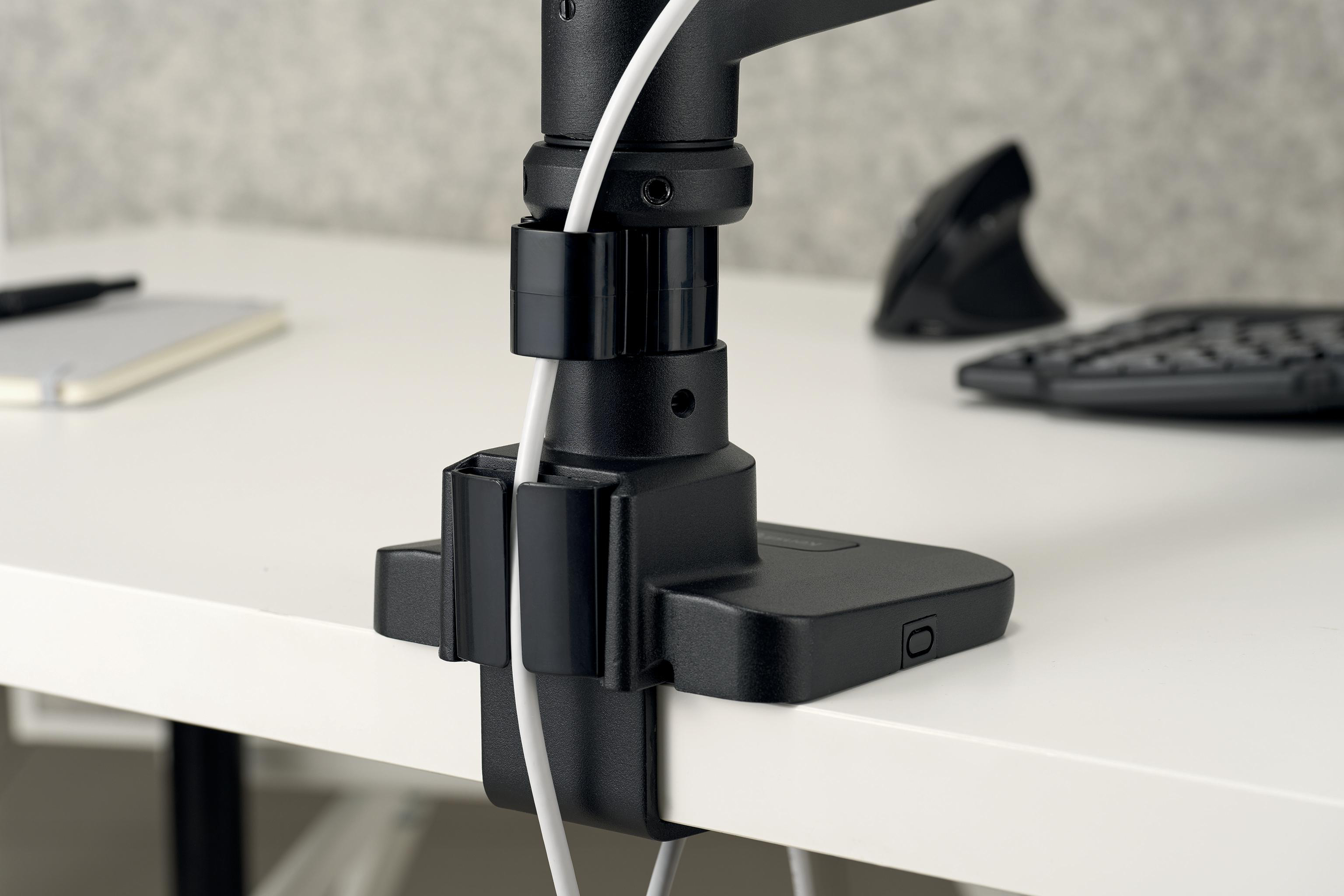 Schwarze Schreibtischhalterung mit weißem Kabel. Maus und Tastatur im Hintergrund. Der Schreibtisch ist weiß.