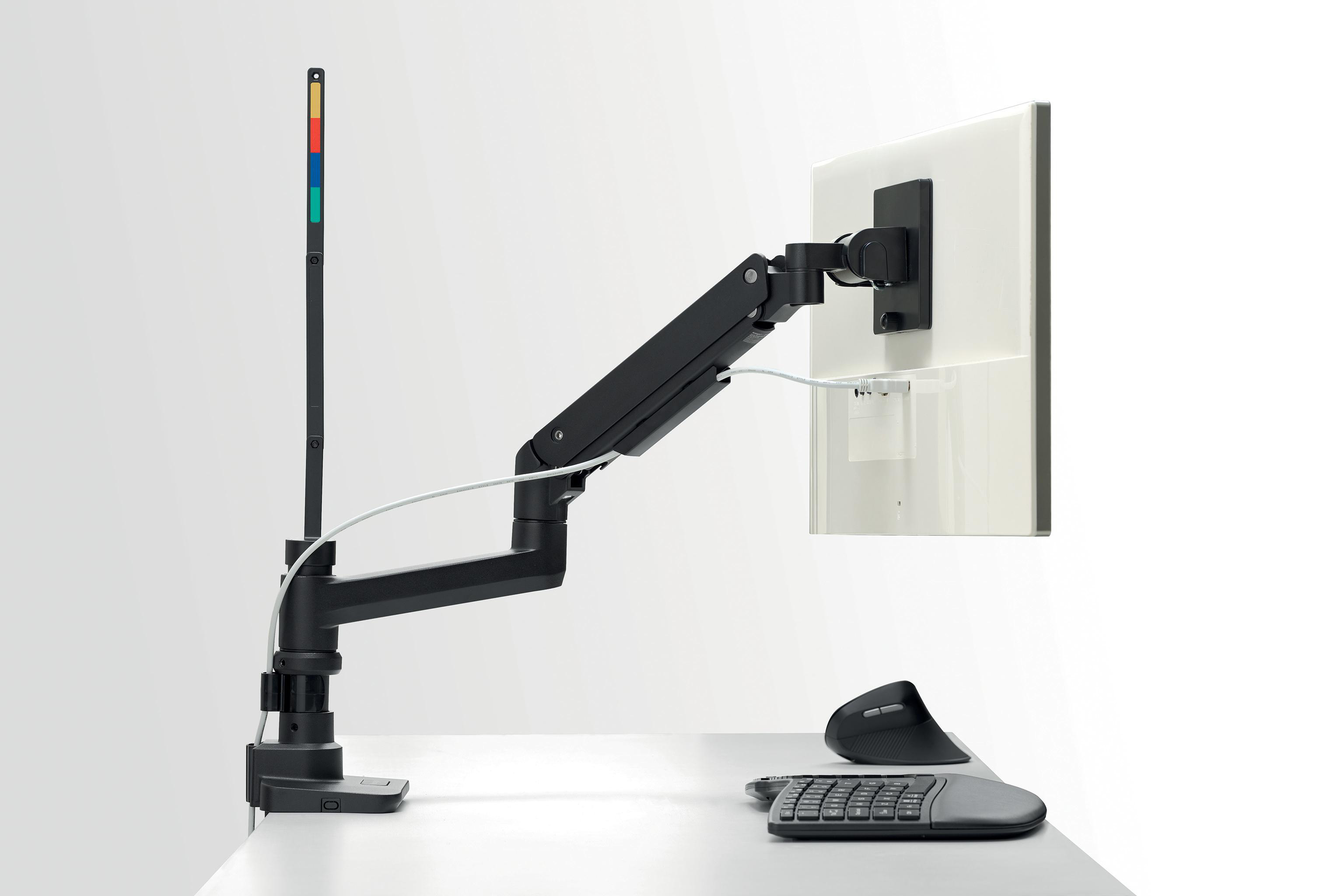 Monitorarm, der einen weißen Bildschirm hält. Auf dem Schreibtisch befinden sich eine Tastatur und eine Maus. Farben: Schwarz, Weiß, Rot und Gelb.