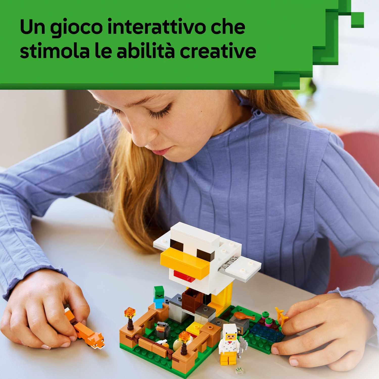 Una ragazza gioca con un set LEGO di Minecraft. Il set include un pollaio, personaggi e una figura di volpe su un tavolo grigio.