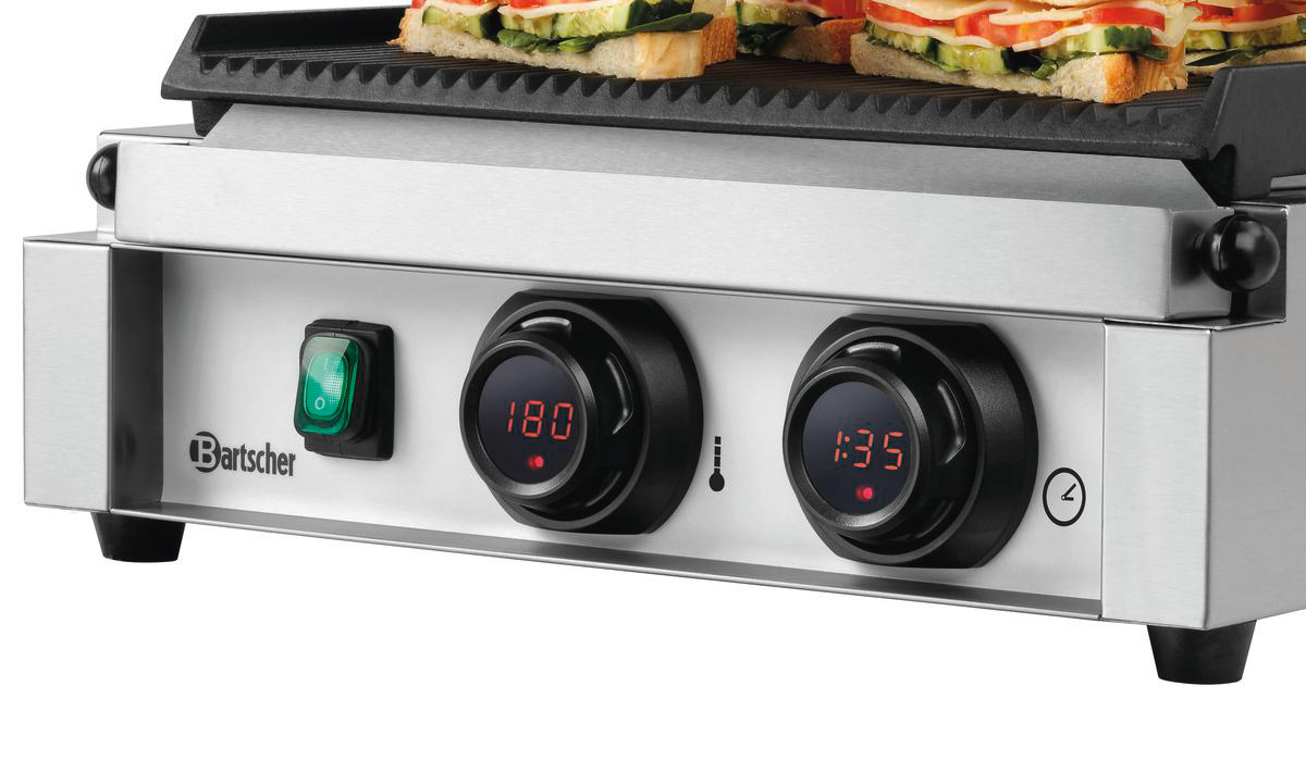 Ein kommerzieller Panini-Grill mit Sandwiches oben. Es hat Drehknöpfe für Temperatur und Zeit sowie einen grünen Netzschalter.