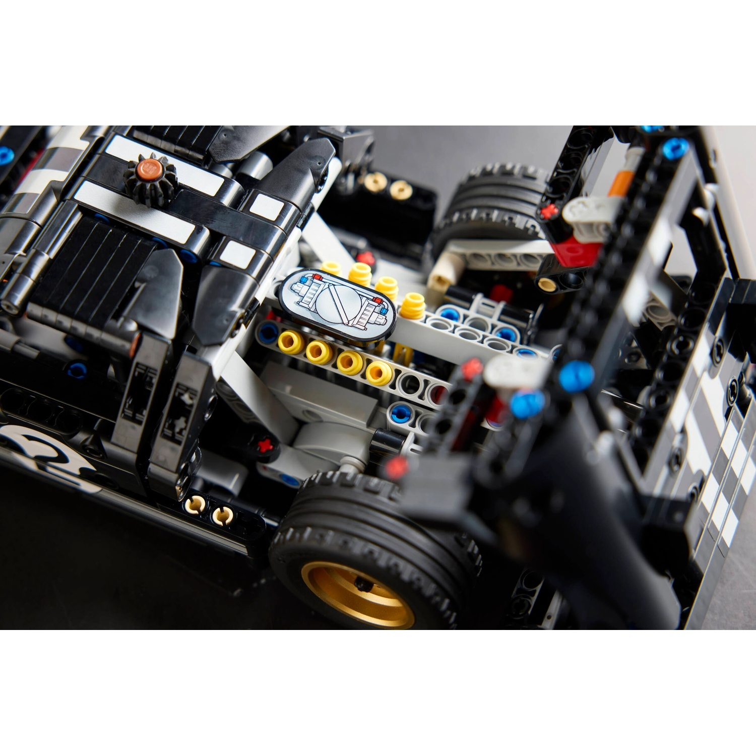Primo piano di un modello di auto da corsa Lego bianco e nero. I dettagli includono pneumatici, componenti del motore e motivo a scacchi.