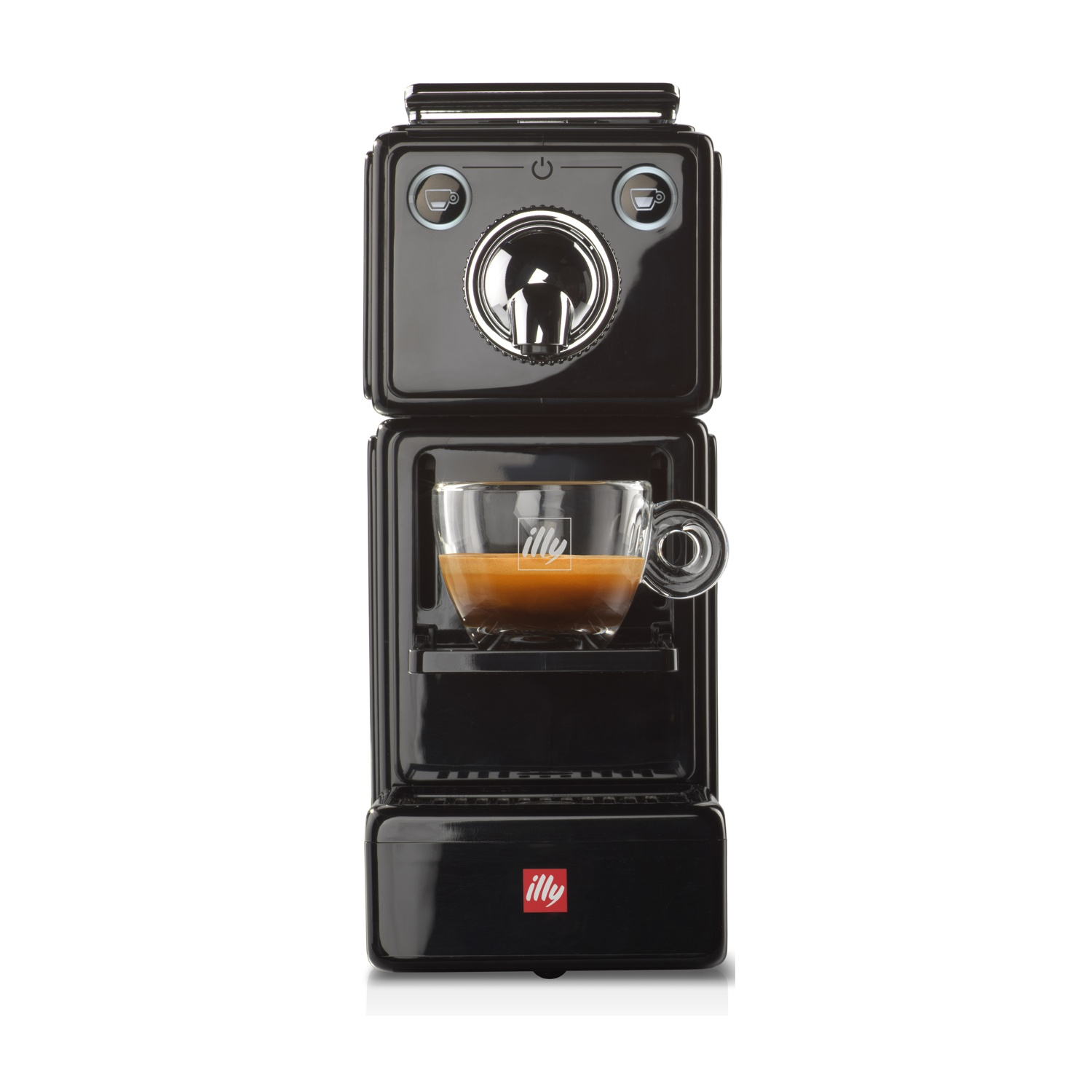 Una macchina per espresso Illy nera con una tazza di vetro piena di caffè. La macchina ha un beccuccio cromato lucido e pulsanti.