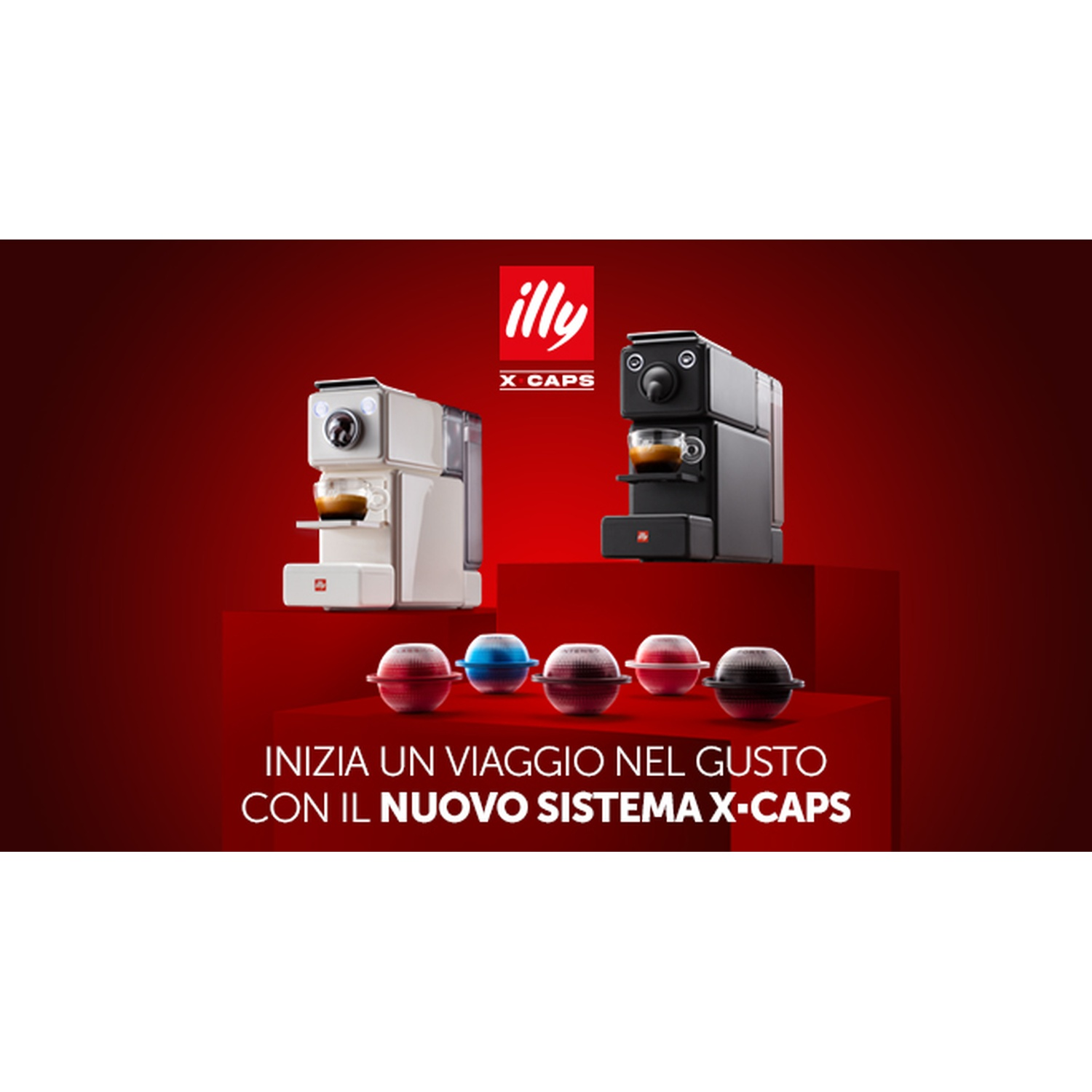 L'immagine presenta due macchine da caffè, bianca e nera. Sotto, capsule di caffè colorate. Testo: 'INIZIA UN VIAGGIO NEL GUSTO CON IL NUOVO SISTEMA X-CAPS'.