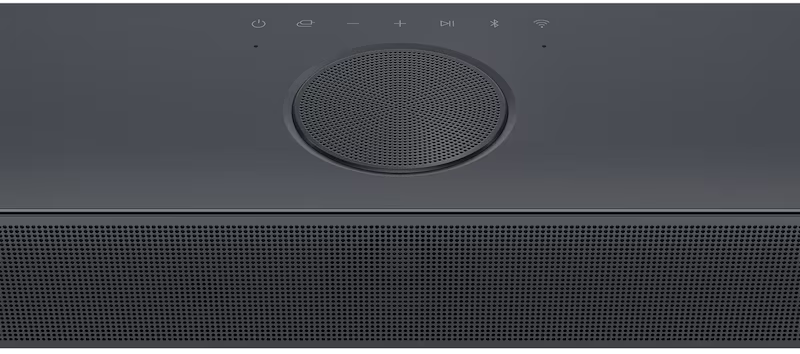 Une barre de son gris foncé avec une grille de haut-parleur en bas. Le dessus comporte des commandes et un haut-parleur circulaire.