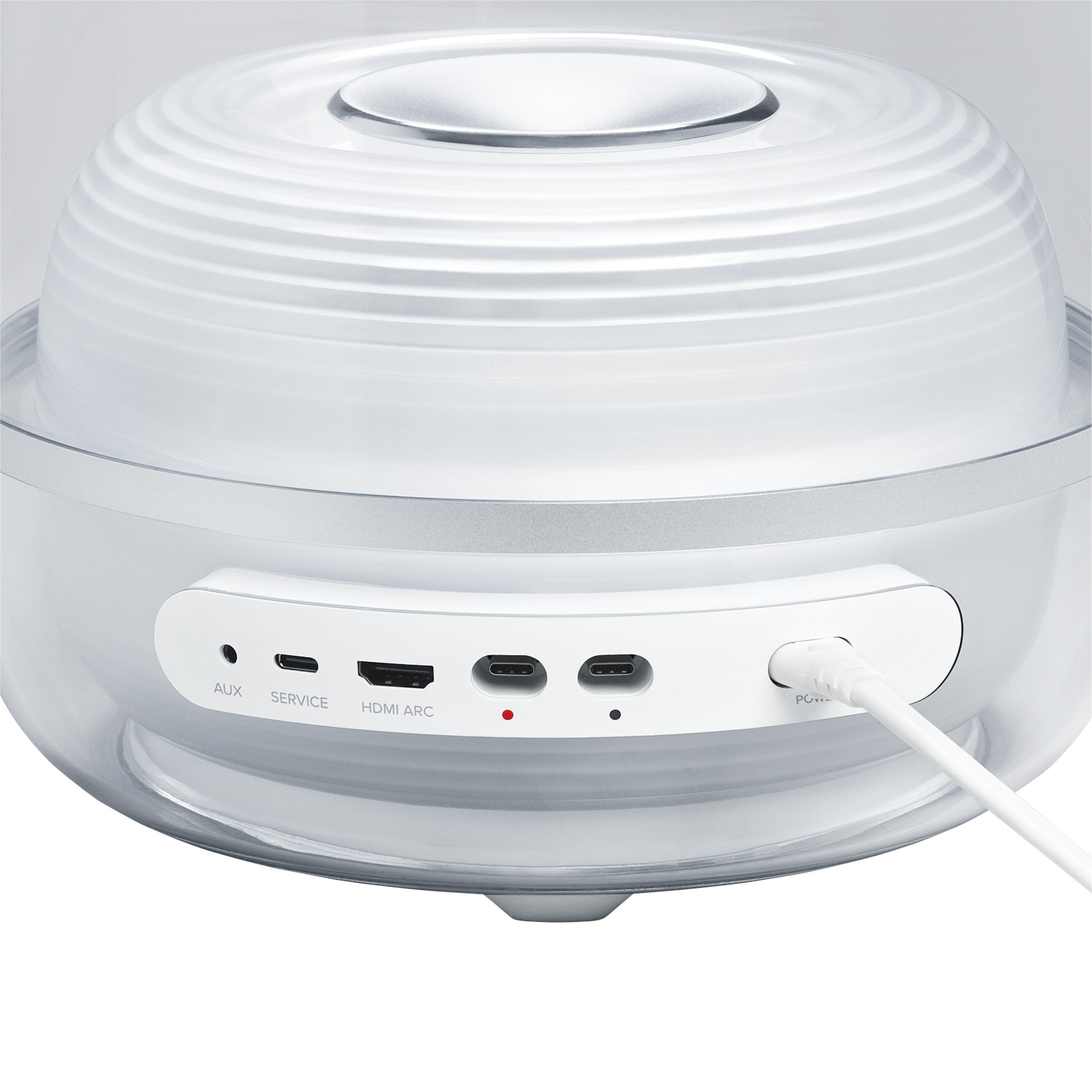 Ein weißer und klarer Lautsprecher mit Anschlüssen AUX, Service, HDMI ARC und USB-C. Ein weißes Kabel ist eingesteckt.