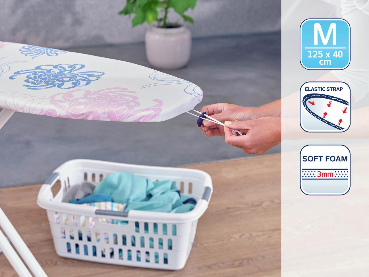 Ein Bügelbrett mit Blumendruck, ein Wäschekorb mit Kleidung und Hände, die den Gummizug des Brettes anpassen.