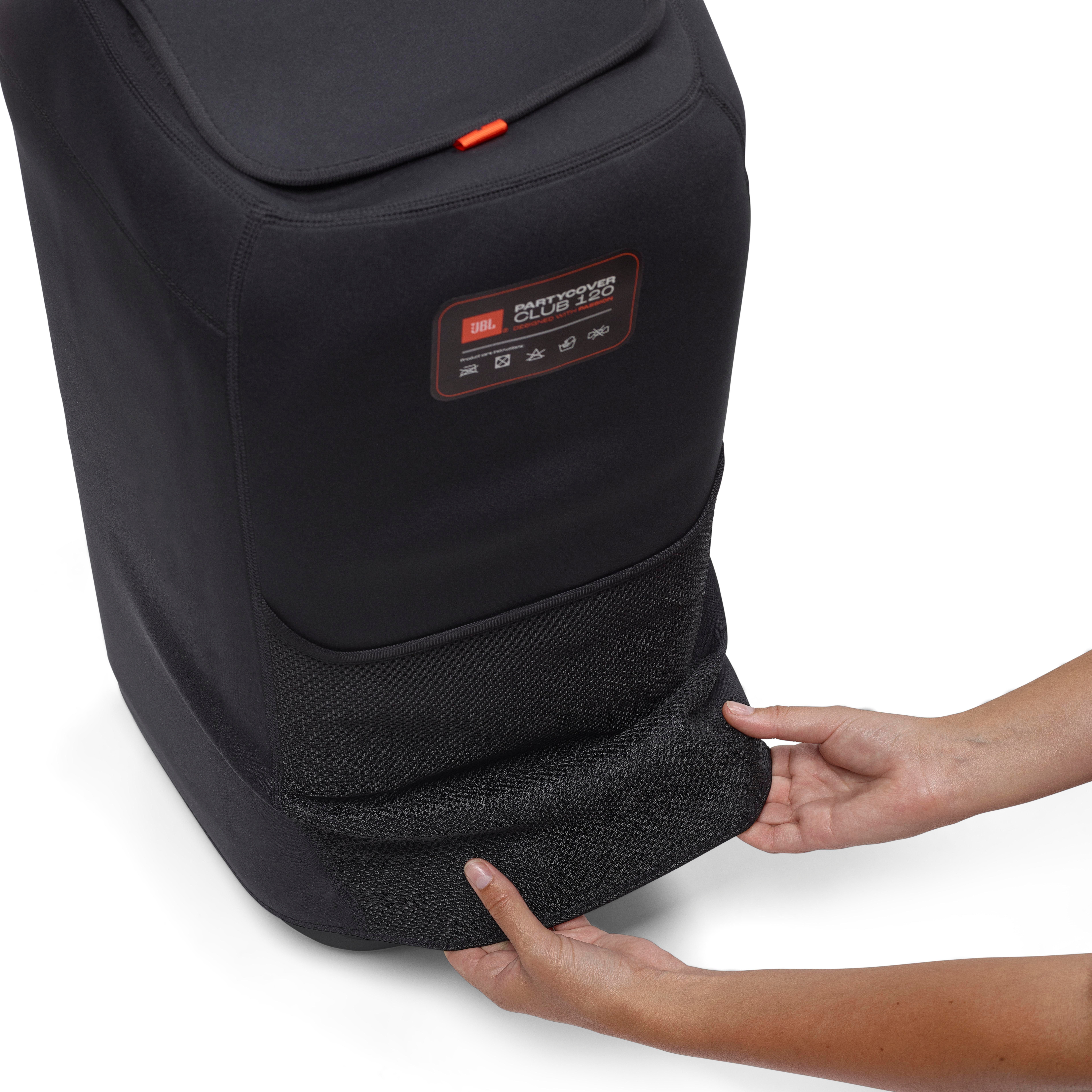 Schwarzes JBL PartyCover Club 120, Hände ziehen die Netztasche hoch. Orangefarbene Akzente und Logo vorhanden.