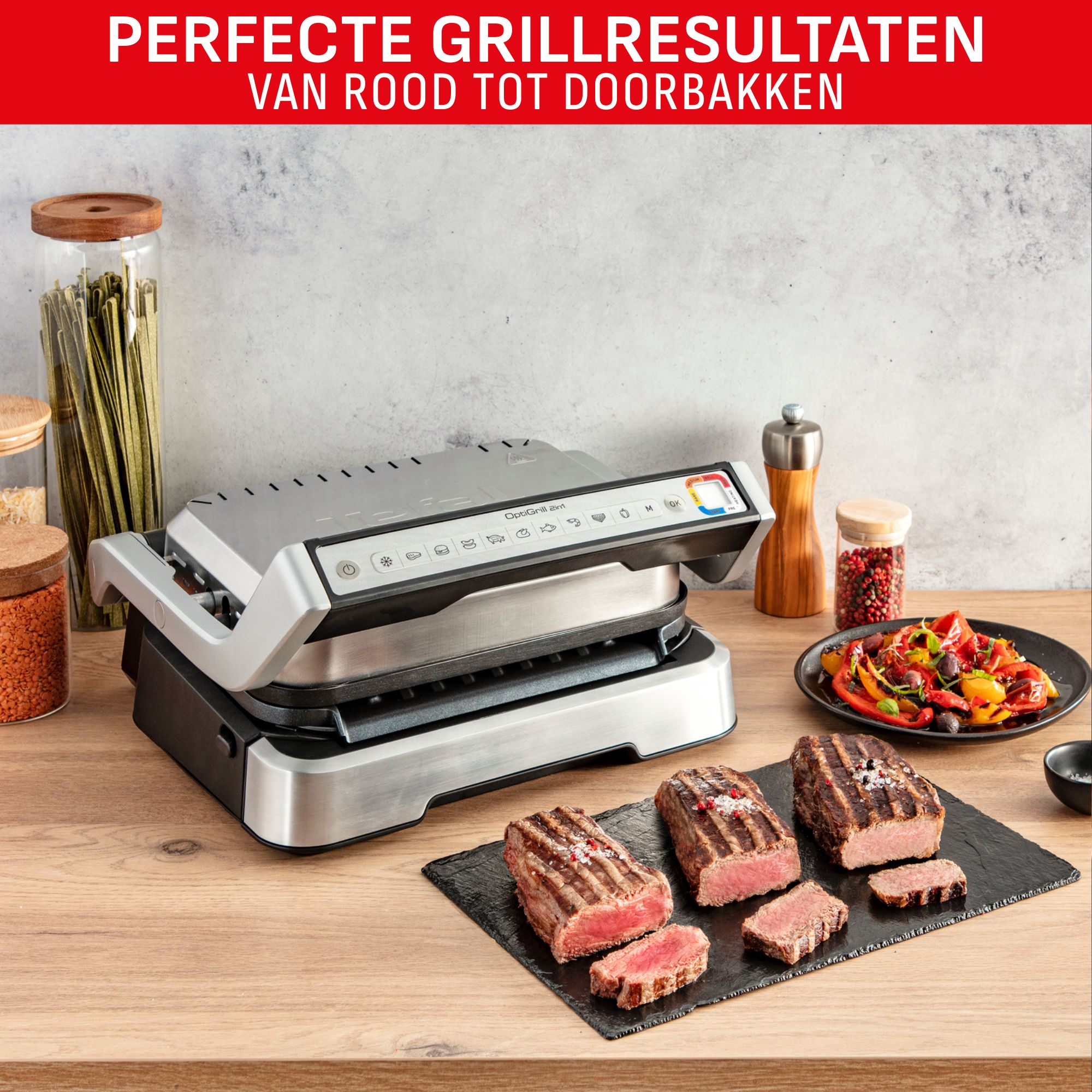 A grill with cooked steaks and vegetables. Various ingredients and spices are visible. The background is a kitchen.