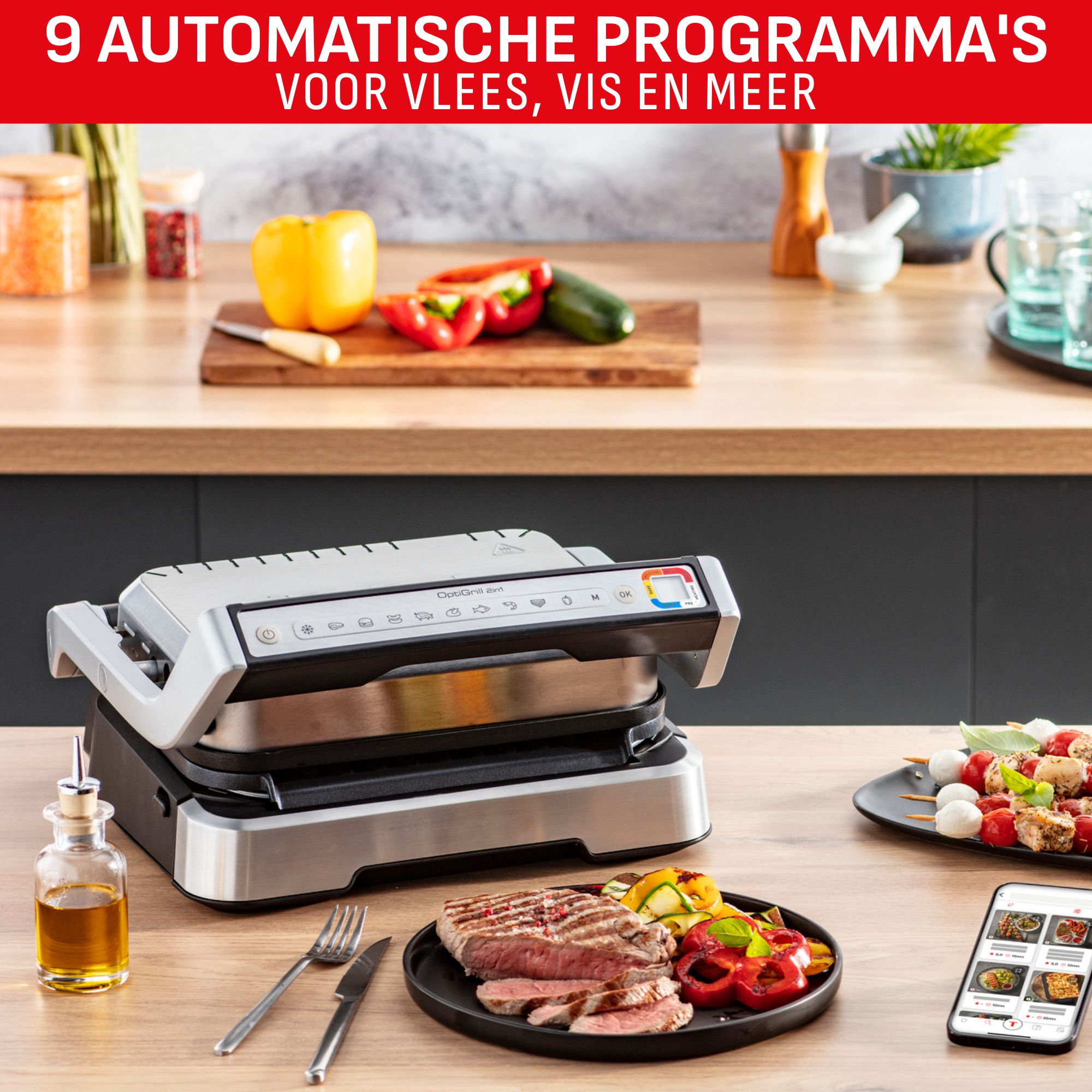 A grill with steak and vegetables, a smartphone with recipes, and skewers, all on a wooden table.