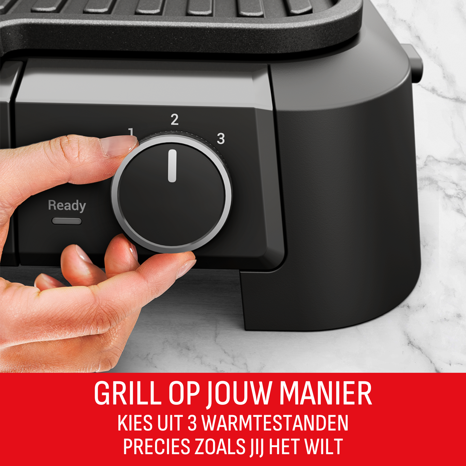 Een hand draait aan een draaiknop op een zwarte grill. De knop heeft de nummers 1, 2 en 3. De achtergrond is marmer.