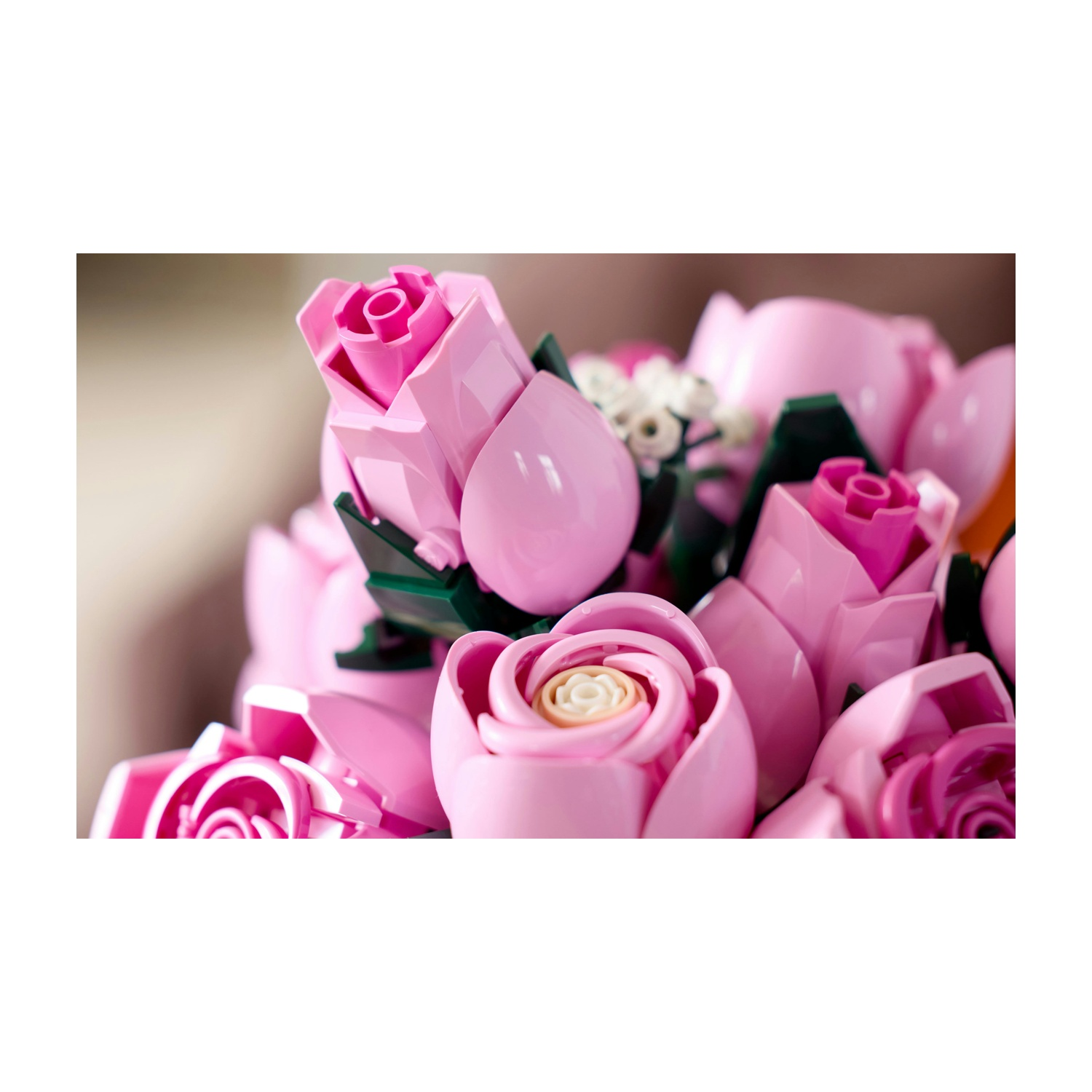 Primo piano di rose di plastica rosa in un bouquet. Alcune sono in piena fioritura, altre sono boccioli. Sono visibili anche foglie verdi.