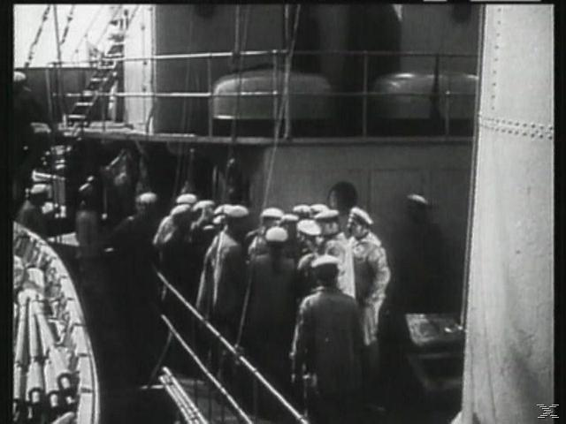 Schwarz-Weiß-Foto. Eine Gruppe Männer in Uniform versammelt sich an Deck eines Schiffes, in der Nähe von Geländern.