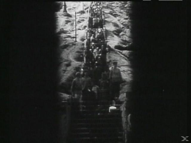 Schwarz-Weiß-Bild einer Gruppe von Menschen, die auf Treppen gehen. Der Hintergrund zeigt mehr Menschen weiter oben auf der Treppe.