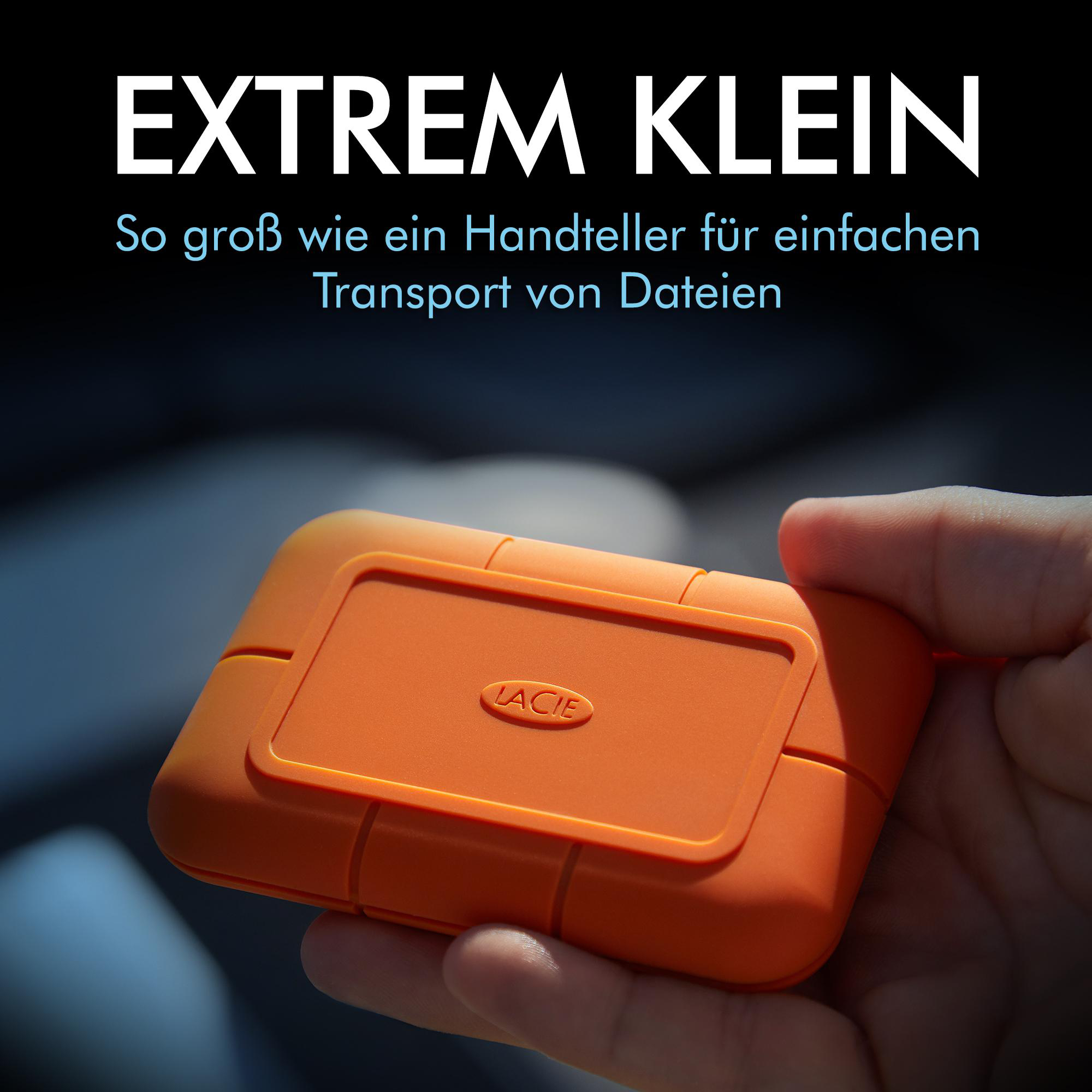 Eine orangefarbene externe Festplatte von LaCie wird von einer Hand gehalten. Der Text oben lautet 'EXTREM KLEIN'.