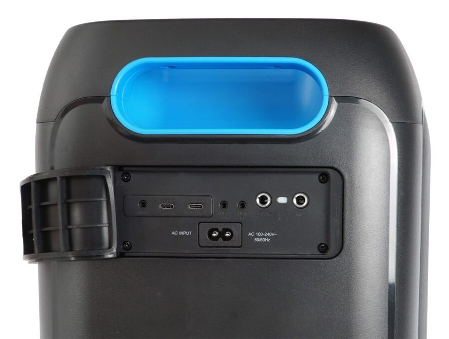 Czarny głośnik z niebieskim uchwytem i portami wejściowymi. Widoczne wejście AC i porty USB. Dominują kolory czarny, niebieski i szary.