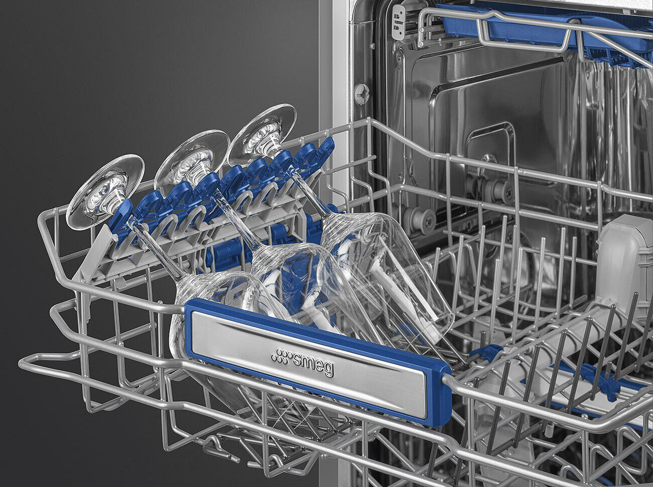 Innenraum eines Geschirrspülers mit Gläsern. Klare Gläser in einem blau akzentuierten Gestell. Edelstahl-Innenraum, SMEG-Logo sichtbar.