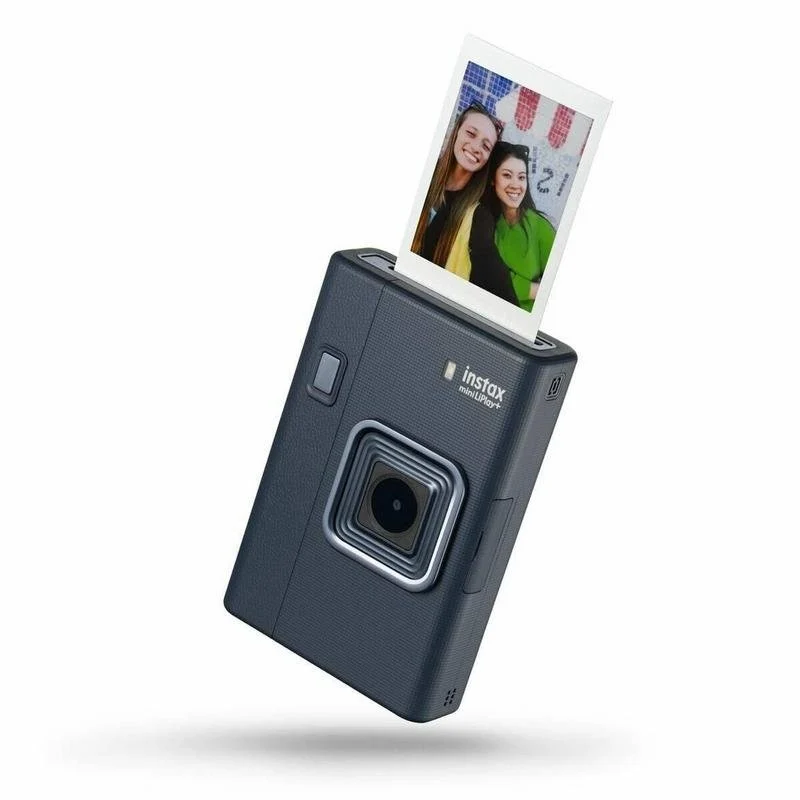 Una cámara Instax Mini LiPlay+ azul oscuro está imprimiendo una foto de dos mujeres sonriendo. La foto sale de la cámara.
