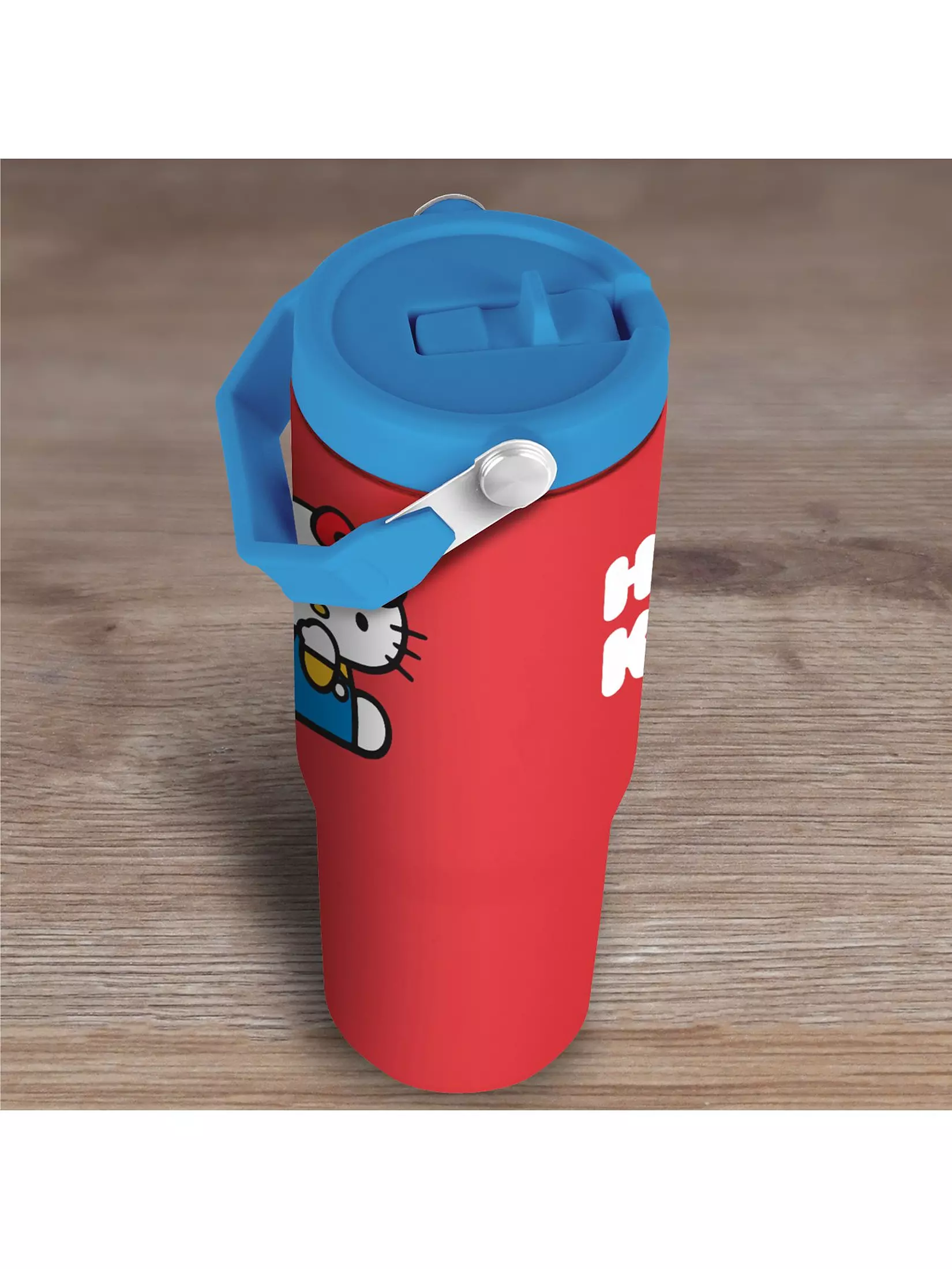 Vaso rojo de Hello Kitty con tapa y asa azules sobre una superficie de madera.