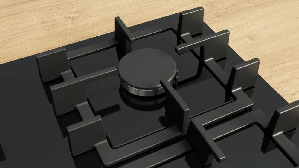 Zbliżenie czarnej płyty gazowej z metalowymi palnikami i drewnianą powierzchnią w tle.