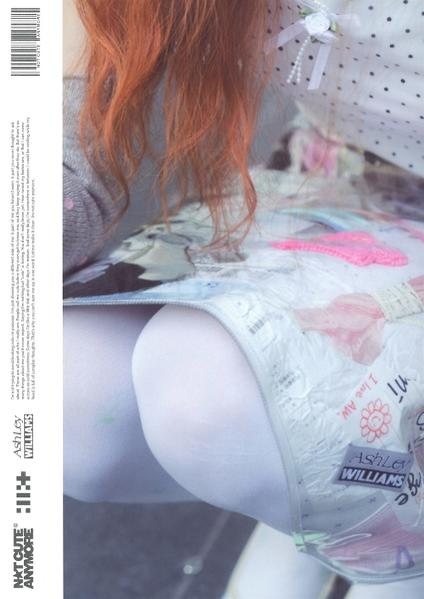Eine Person mit rotem Haar trägt ein Kleid. Das Kleid hat eine transparente Schicht. Weiße Strumpfhosen sind sichtbar. Links steht Text.