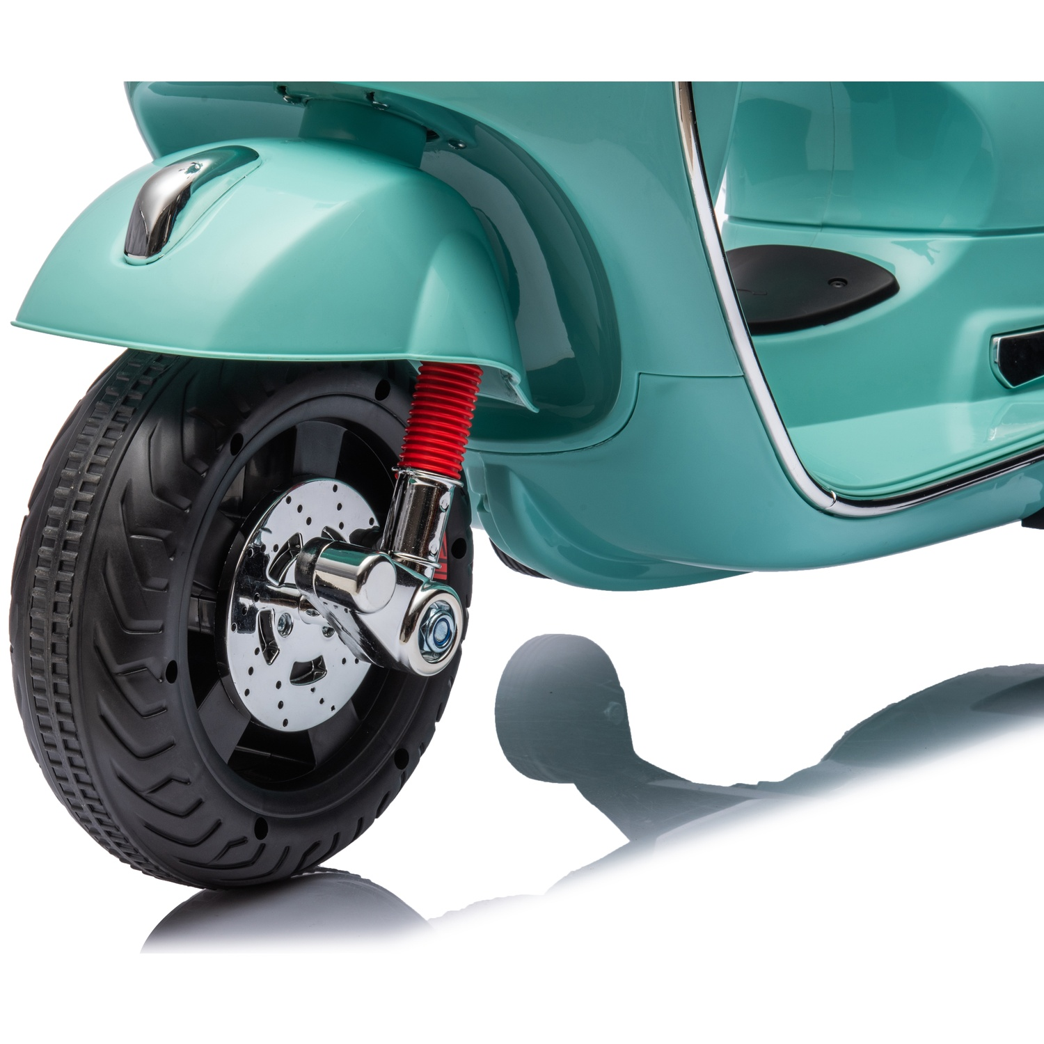 Roue avant d'un scooter turquoise, pneu noir, détails chromés et amortisseur rouge. Le scooter est sur une surface blanche.