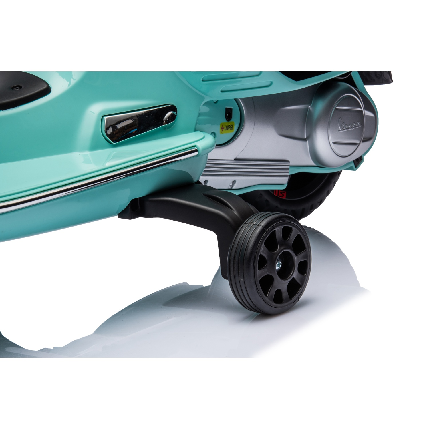 Un scooter Vespa turquoise avec une roue noire est sur une surface blanche. La Vespa a un moteur argenté et un siège noir.