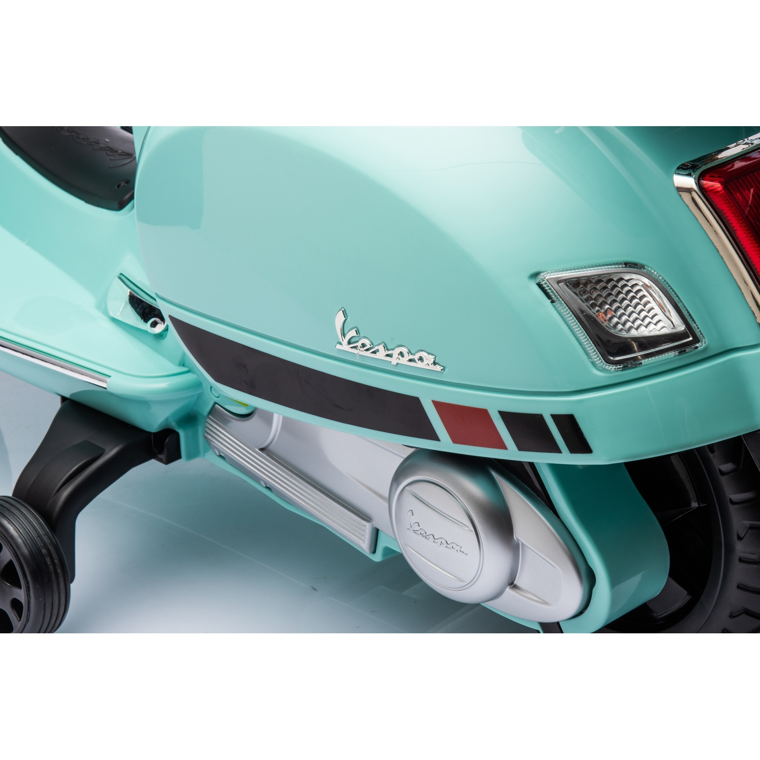 Gros plan d'un scooter Vespa turquoise. Comprend le logo Vespa, des rayures noires et rouges et un cache moteur argenté.