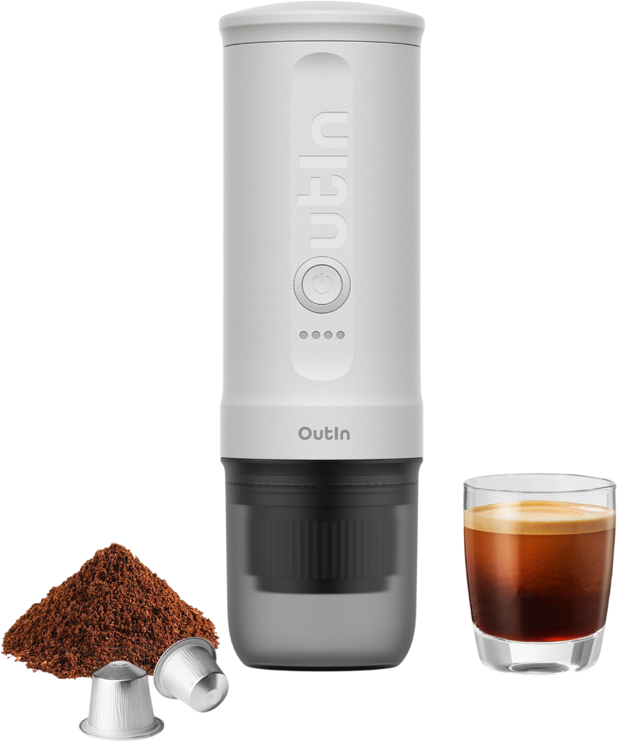 Eine tragbare, weiße Espressomaschine mit Kaffeepulver, Kapseln und einem Glas Espresso auf schwarzem Hintergrund.