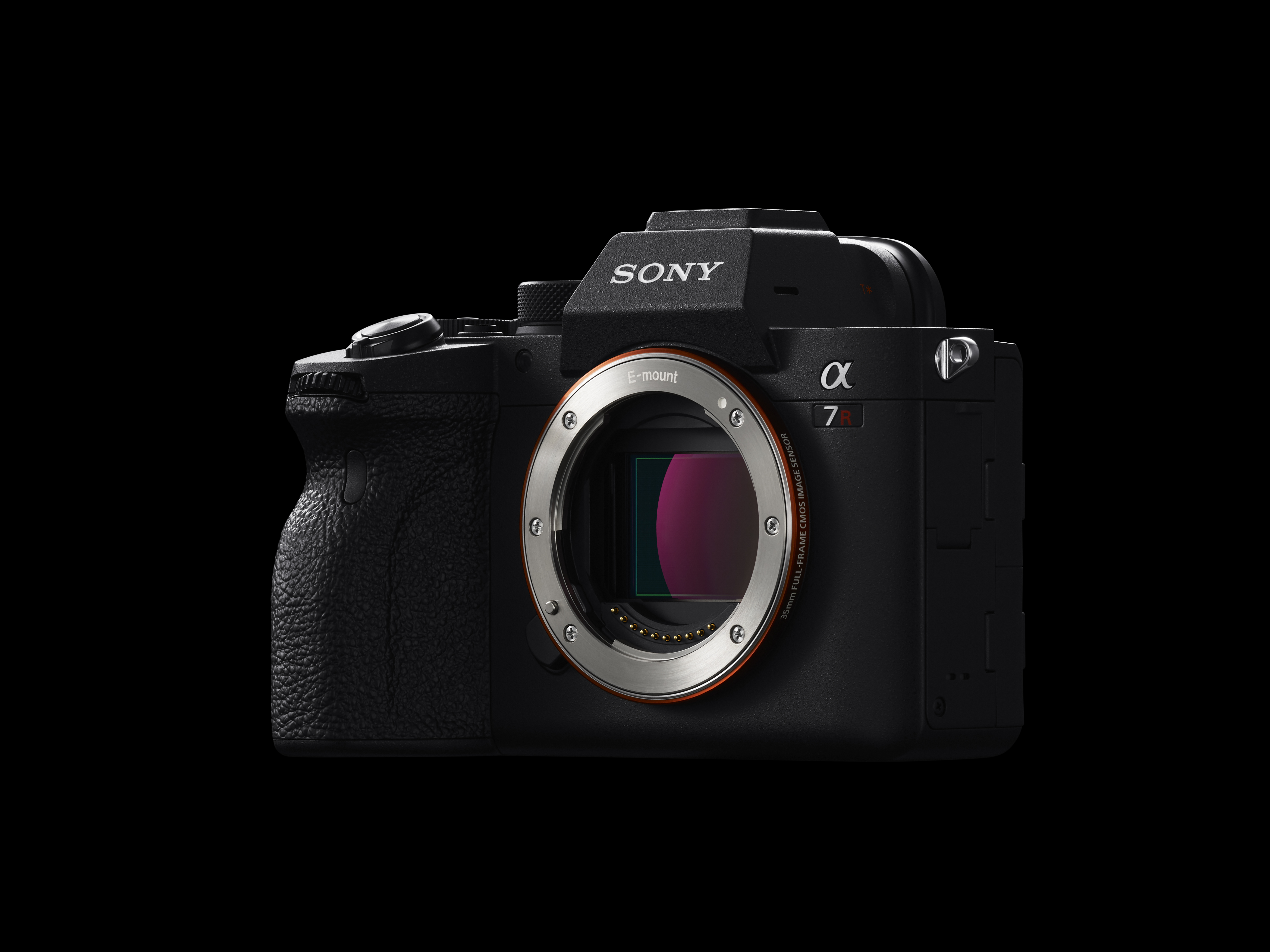 Una fotocamera Sony Alpha 7R nera su sfondo nero. L'obiettivo è visibile.