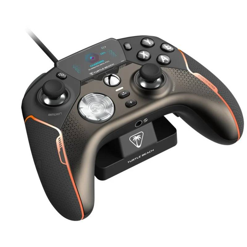 Un mando de juegos Turtle Beach negro y gris se está cargando en su soporte. Tiene detalles en naranja y una pequeña pantalla.