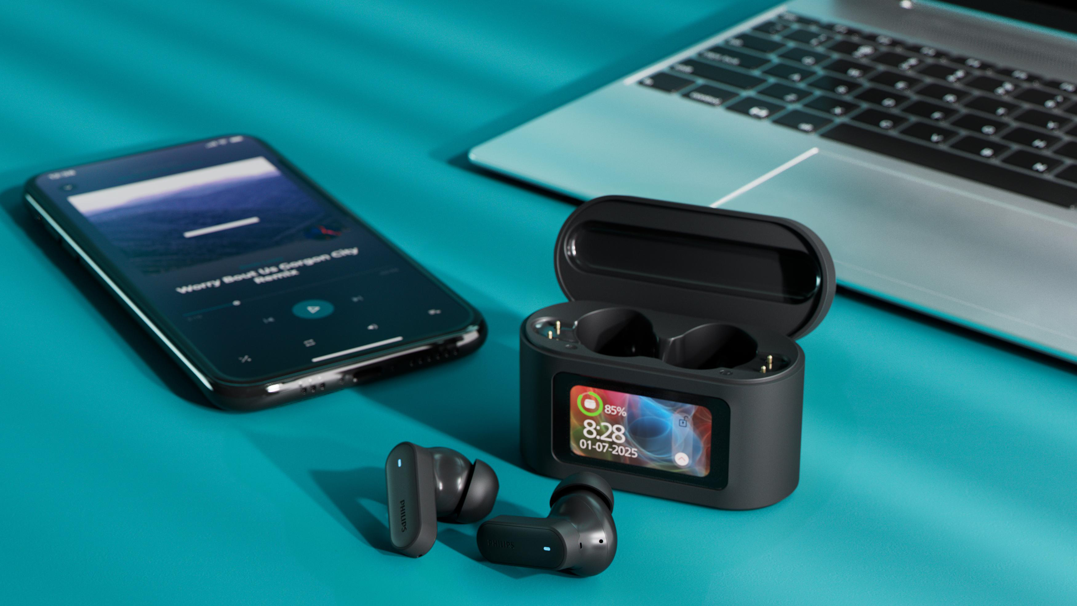 Schwarze Ohrhörer, Ladecase, Telefon und Laptop auf blauem Untergrund. Auf dem Telefon läuft Musik. Das Case zeigt Zeit und Akku.