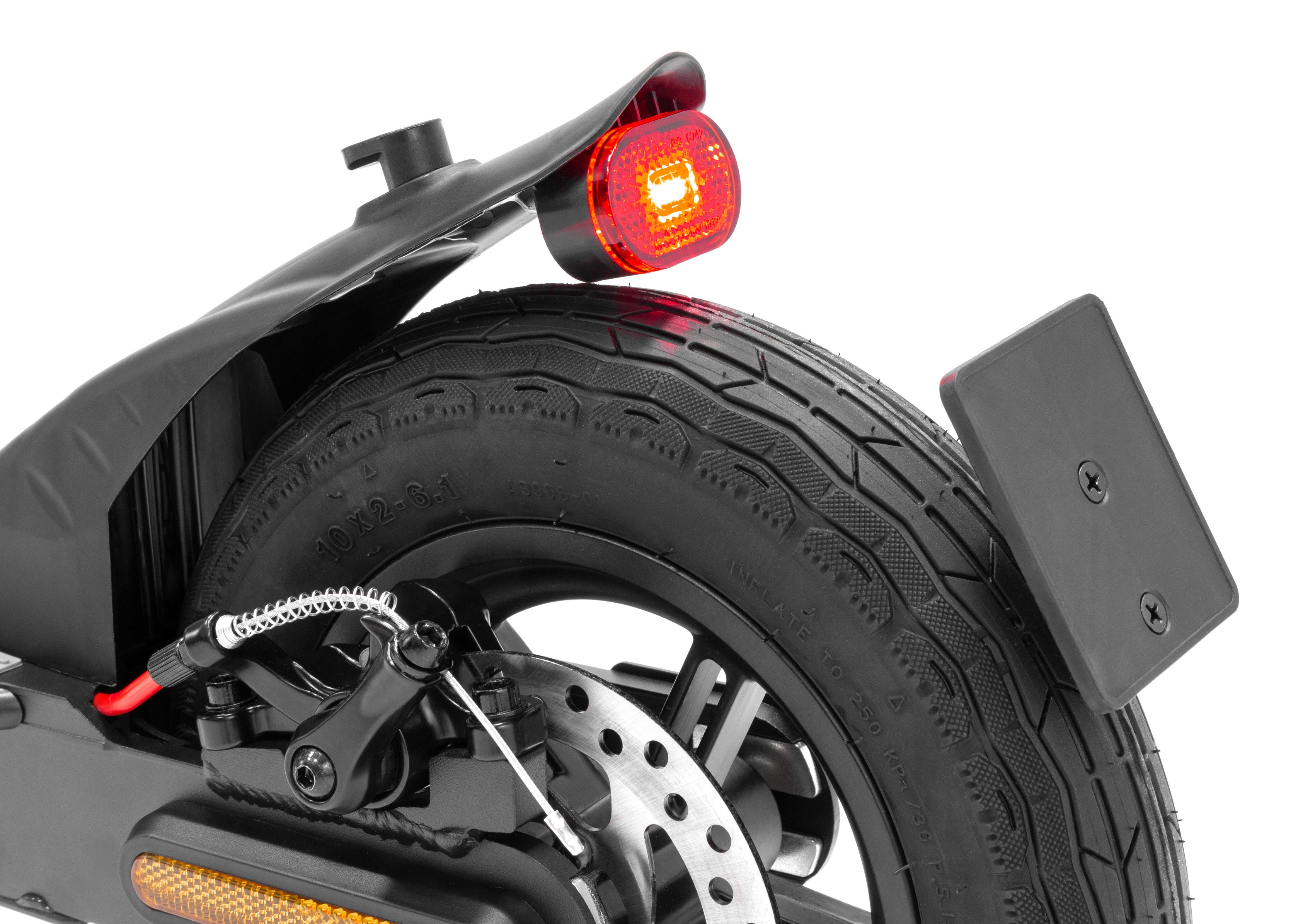 Zbliżenie tylnego koła hulajnogi elektrycznej z oponą, tarczą hamulcową, czerwonym światłem i tablicą rejestracyjną. Białe tło.