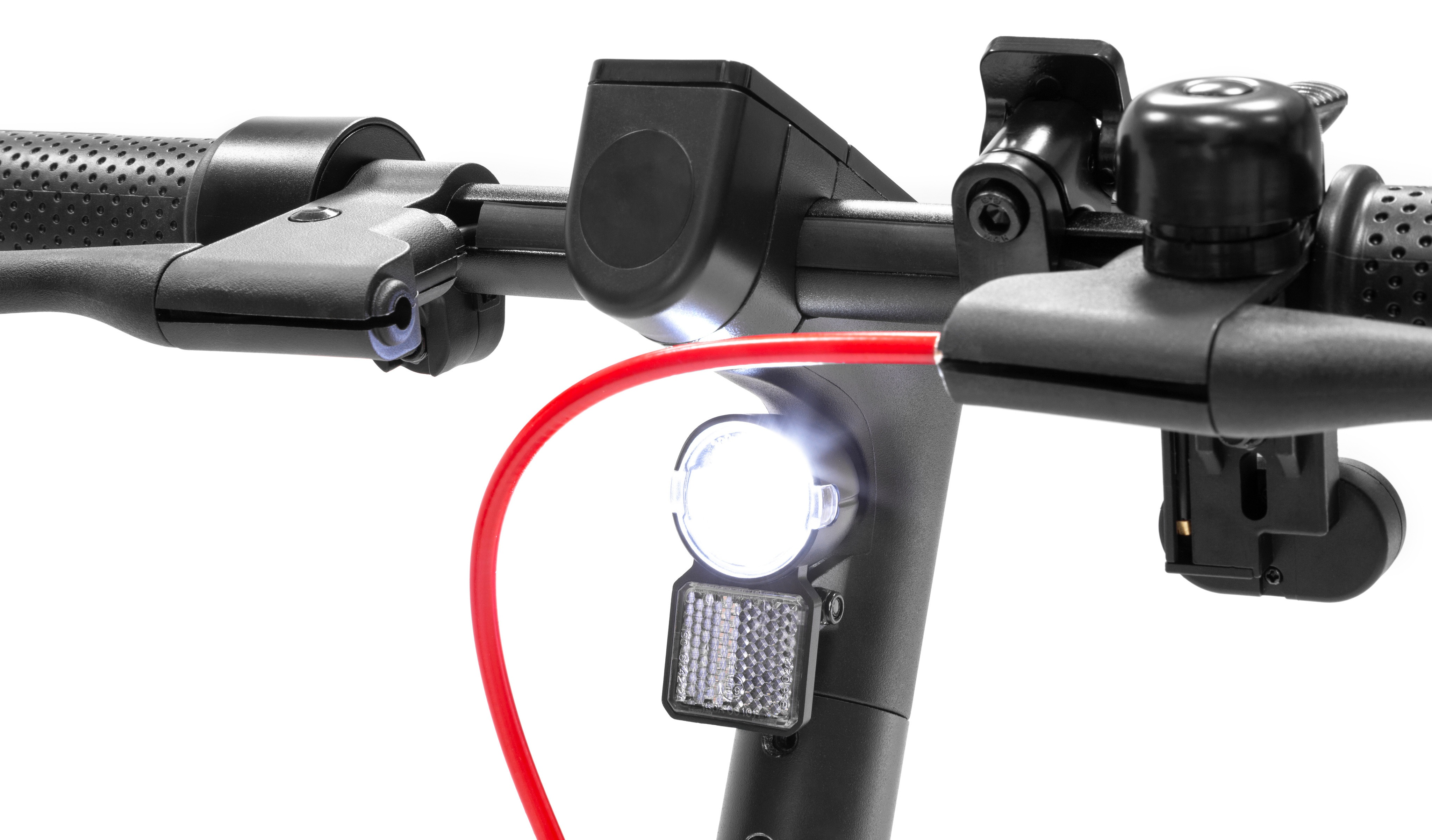 Zbliżenie kierownicy hulajnogi elektrycznej. Widoczne czarne elementy metalowe, jasny biały reflektor i czerwony kabel.