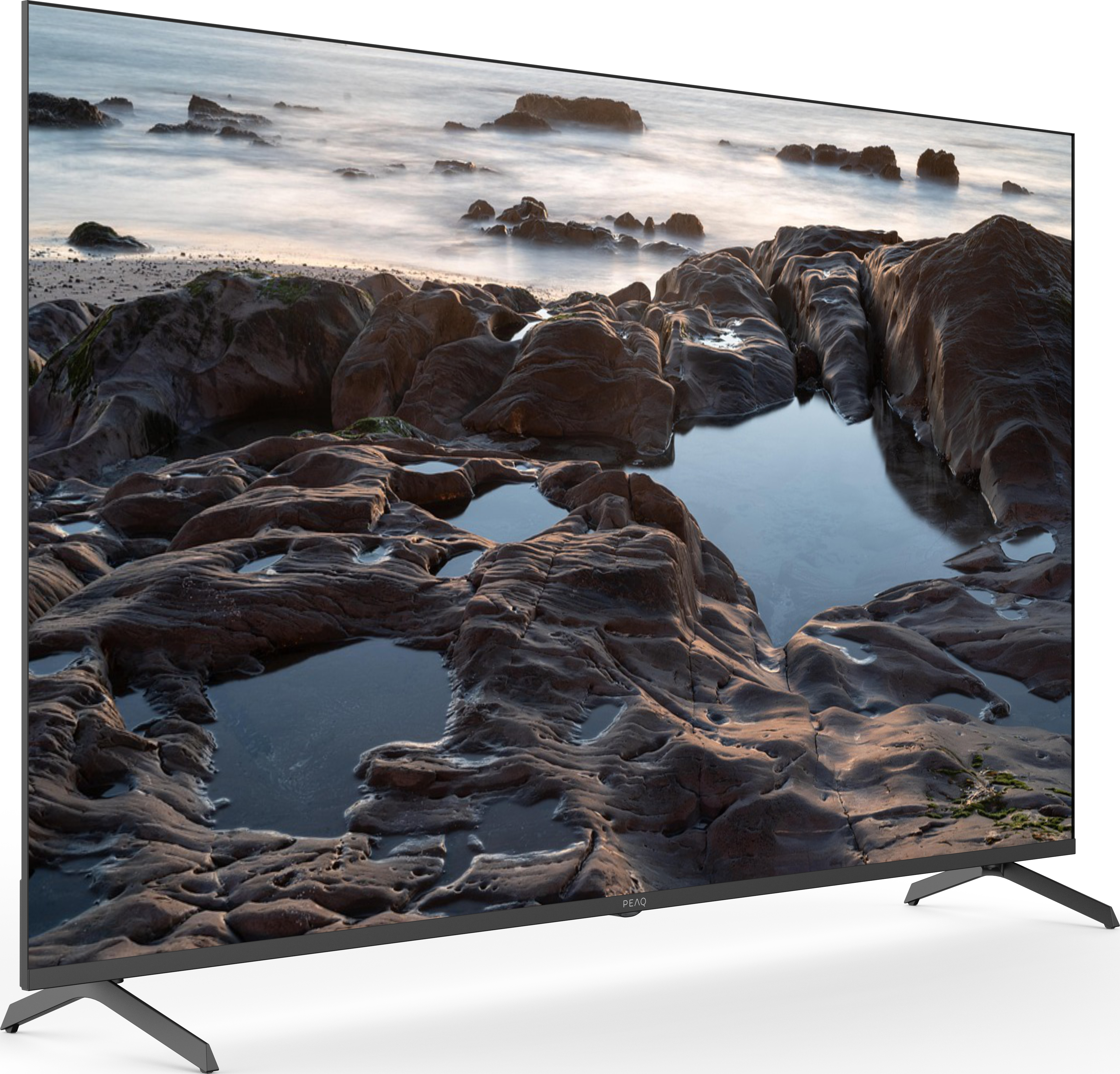 TV montrant une scène de plage. Premier plan avec des piscines rocheuses, arrière-plan avec plage et mer.