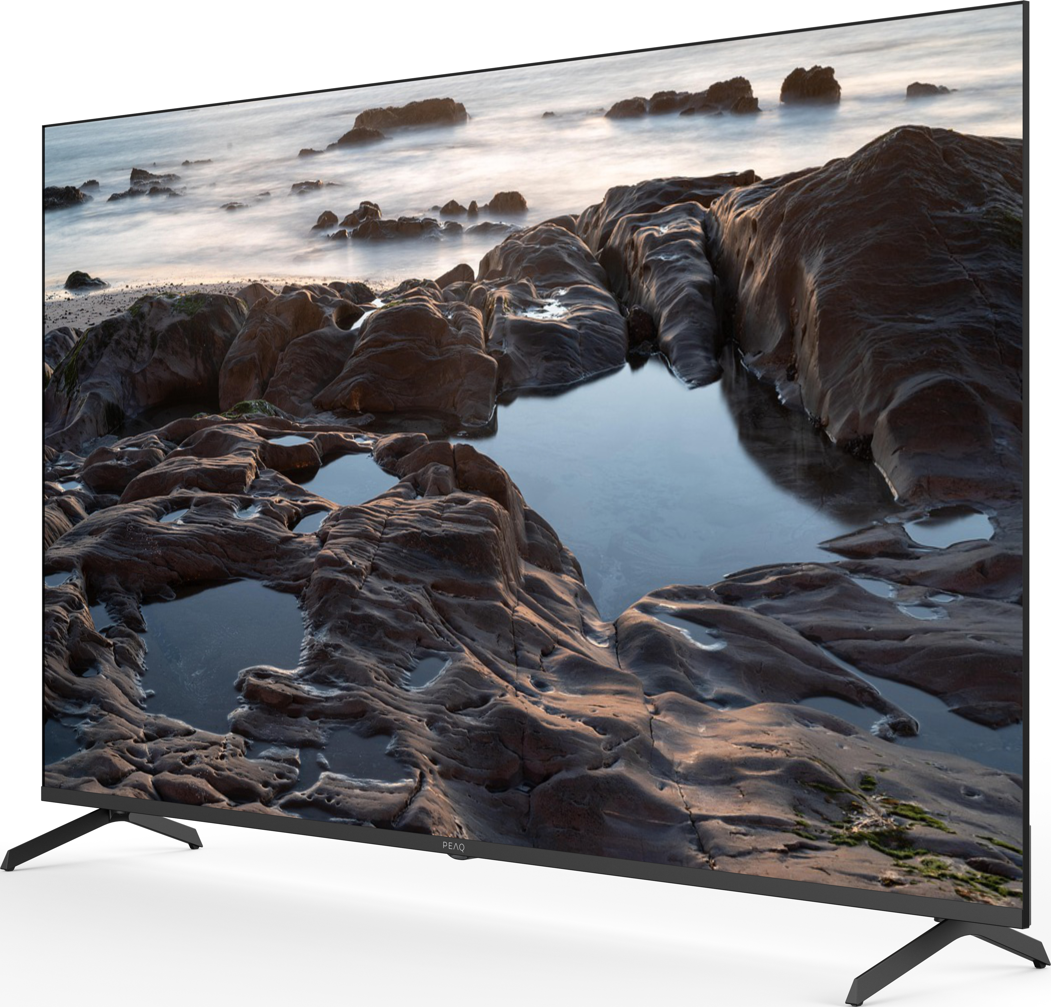 TV montrant une scène côtière. Rochers au premier plan, mer en arrière-plan. Exposition longue floue.