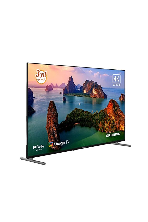Bir Grundig 4K Ultra HD TV, manzaralı bir ada görüntüsü sergiliyor. Dolby Vision ve Google TV'ye sahip. TV, gümüş ayaklar üzerinde.