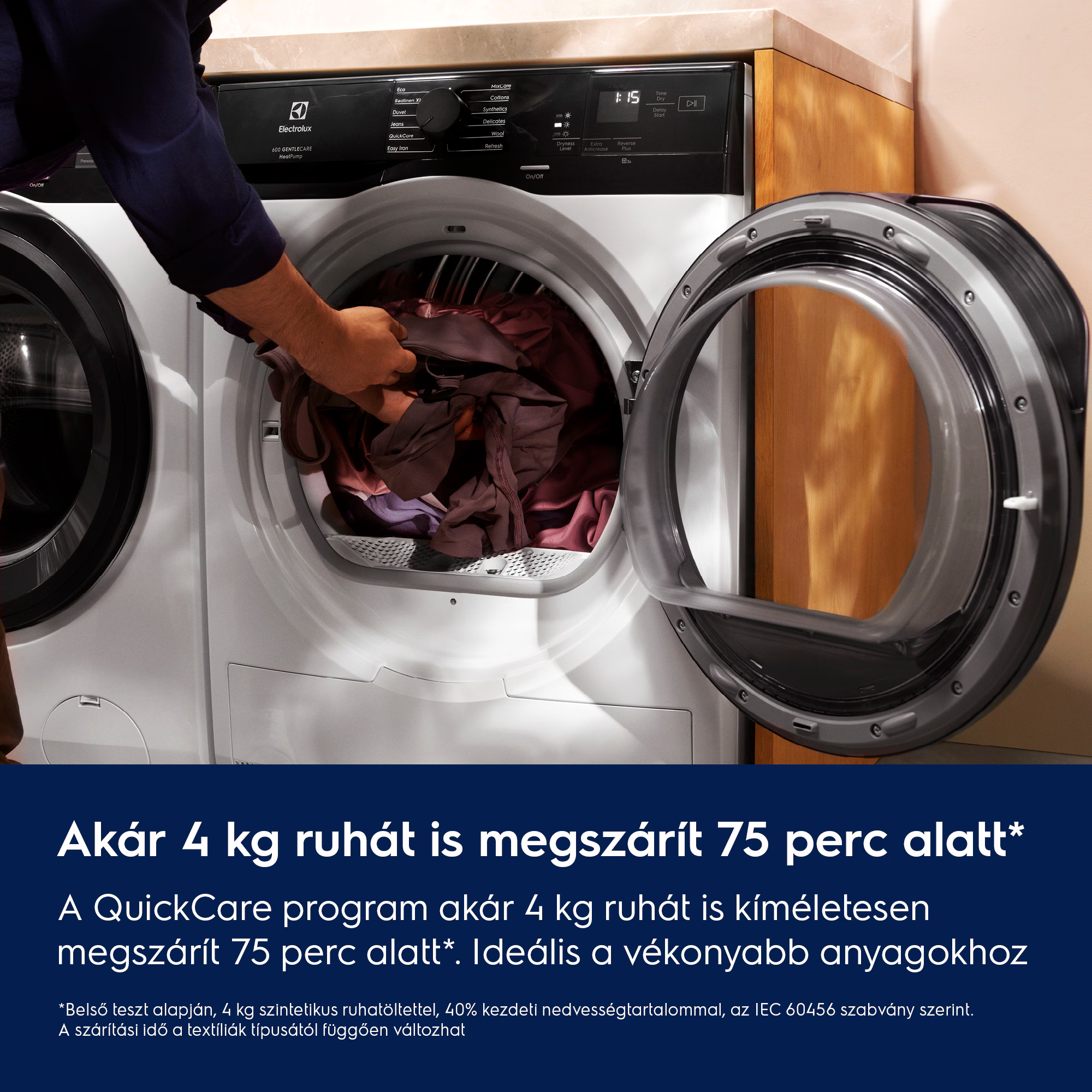 Egy személy ruhákat tesz egy fehér szárítógépbe, nyitott ajtóval. A szárító mutatja az időt és a beállításokat.