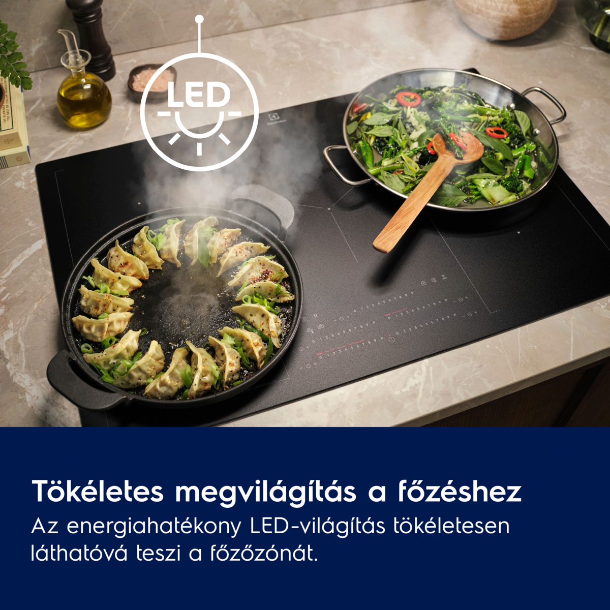 Fekete főzőlap gombócokkal egy serpenyőben és zöldségekkel egy másikban. LED-lámpa és palackok láthatók.