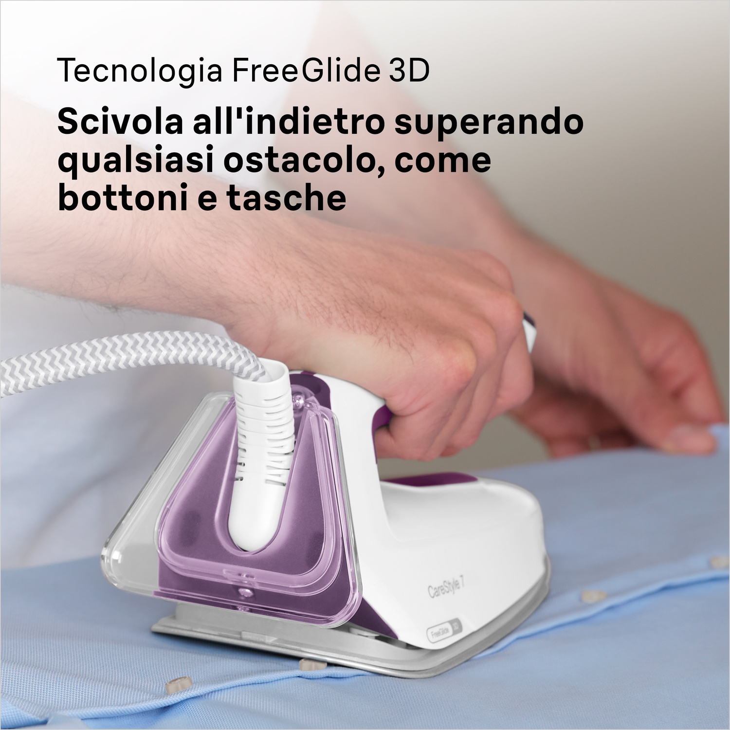 Un ferro da stiro bianco e viola scivola su una camicia blu. Una mano tiene il ferro. Il testo recita: FreeGlide 3D, scivolando sugli ostacoli.