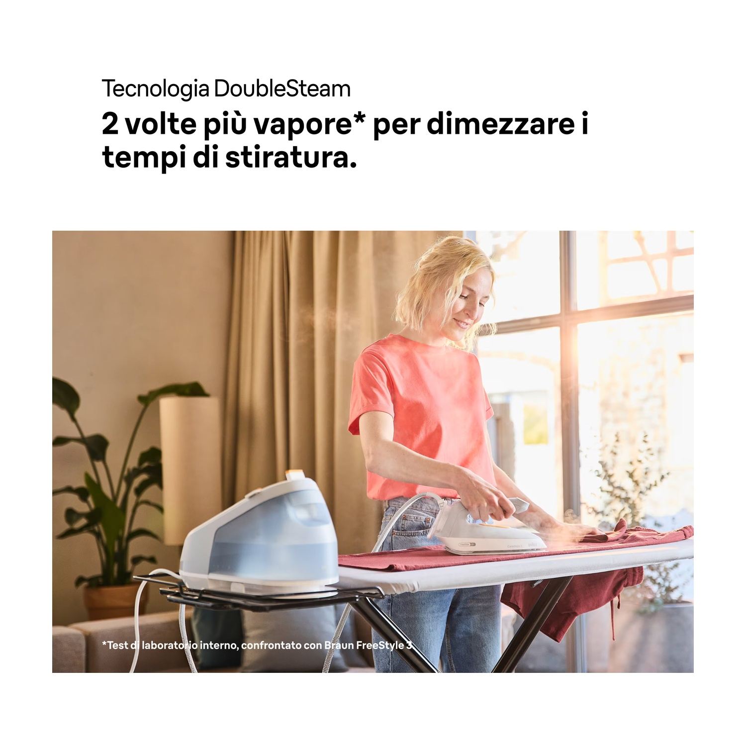 Una donna stira i vestiti. Vengono utilizzati un ferro da stiro a vapore e un'asse da stiro. La stanza ha luce naturale e una pianta.