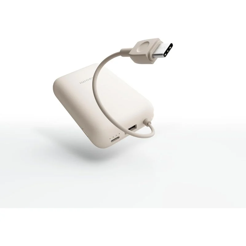 Un banco de energía beige con un cable adjunto y un conector USB-C, aislado sobre un fondo blanco.