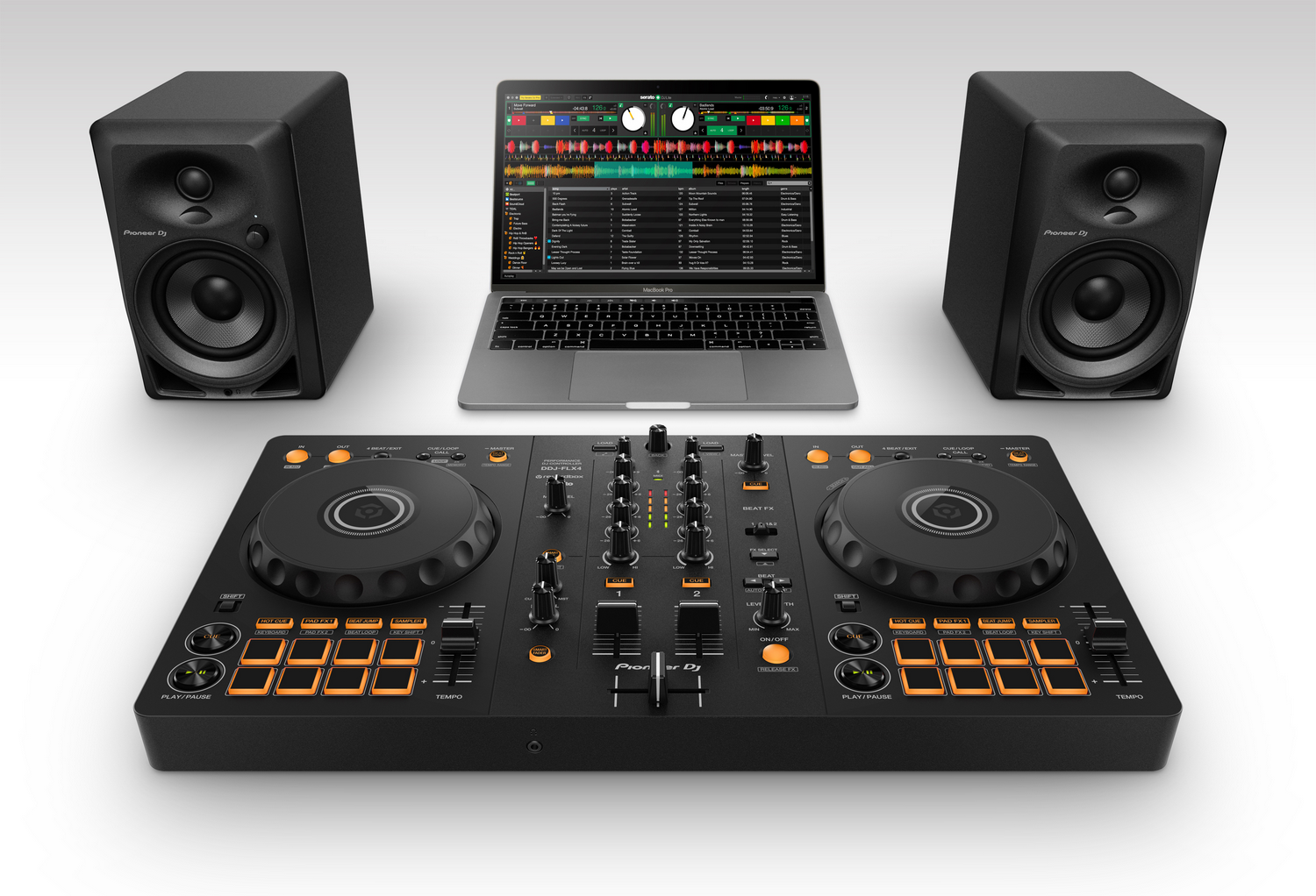 Configuración de DJ con portátil, controlador de DJ y dos altavoces negros sobre una superficie blanca.