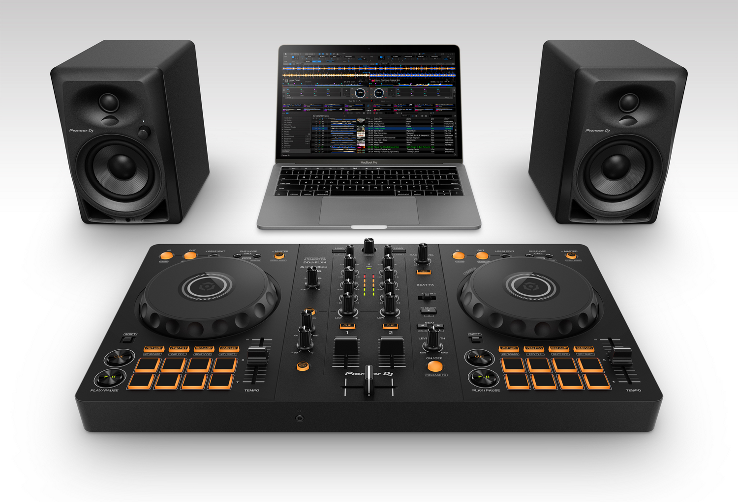 Una configuración de DJ con altavoces, una laptop que muestra software de DJ y un controlador de DJ con controles naranjas y negros.