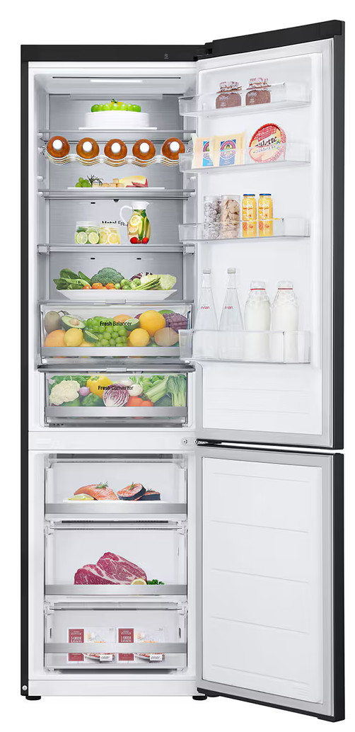 Otwarta lodówka wypełniona jedzeniem: owoce, warzywa, napoje, ser i mięso. Zawiera półki, szuflady i butelki. Czarny wygląd zewnętrzny.