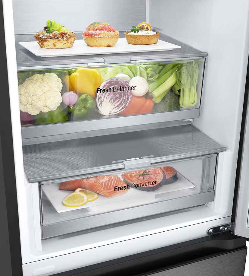 Wnętrze lodówki: ciasta, warzywa i łosoś. Lodówka ma szuflady z napisem 'Fresh Balancer' i 'Fresh Converter'.