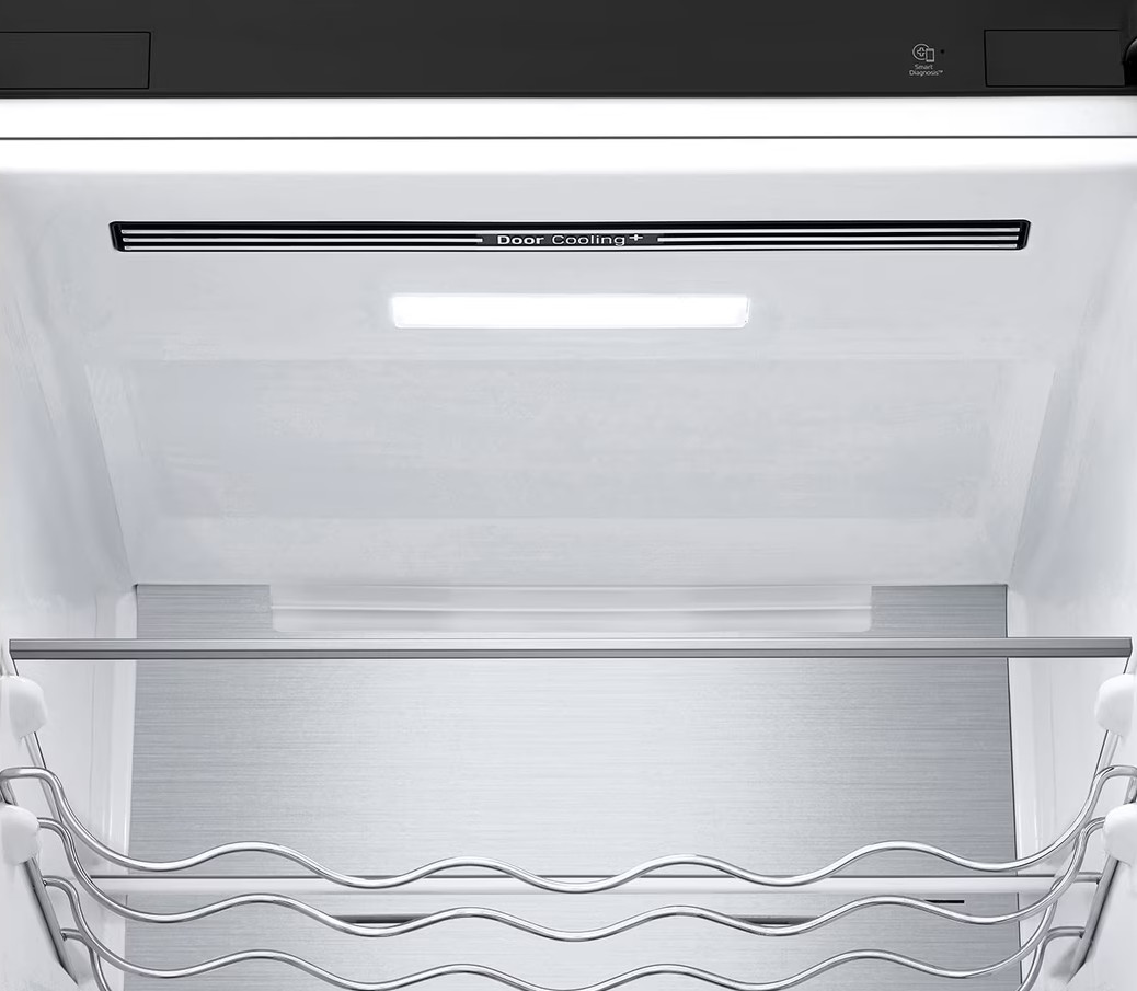 Wnętrze lodówki. Wyposażone w półkę, stojak na wino i technologię Door Cooling+. Wnętrze białe z metalicznymi akcentami.