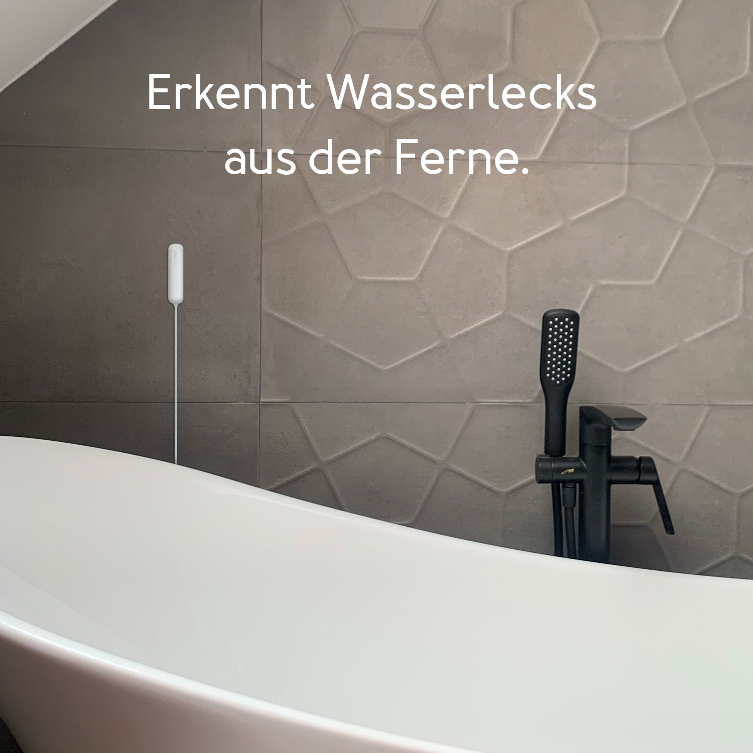 Eine weiße Badewanne mit schwarzer Armatur, Duschkopf und Lecksucher. Graue Fliesenwand. Text: Erkennt Wasserlecks aus der Ferne.