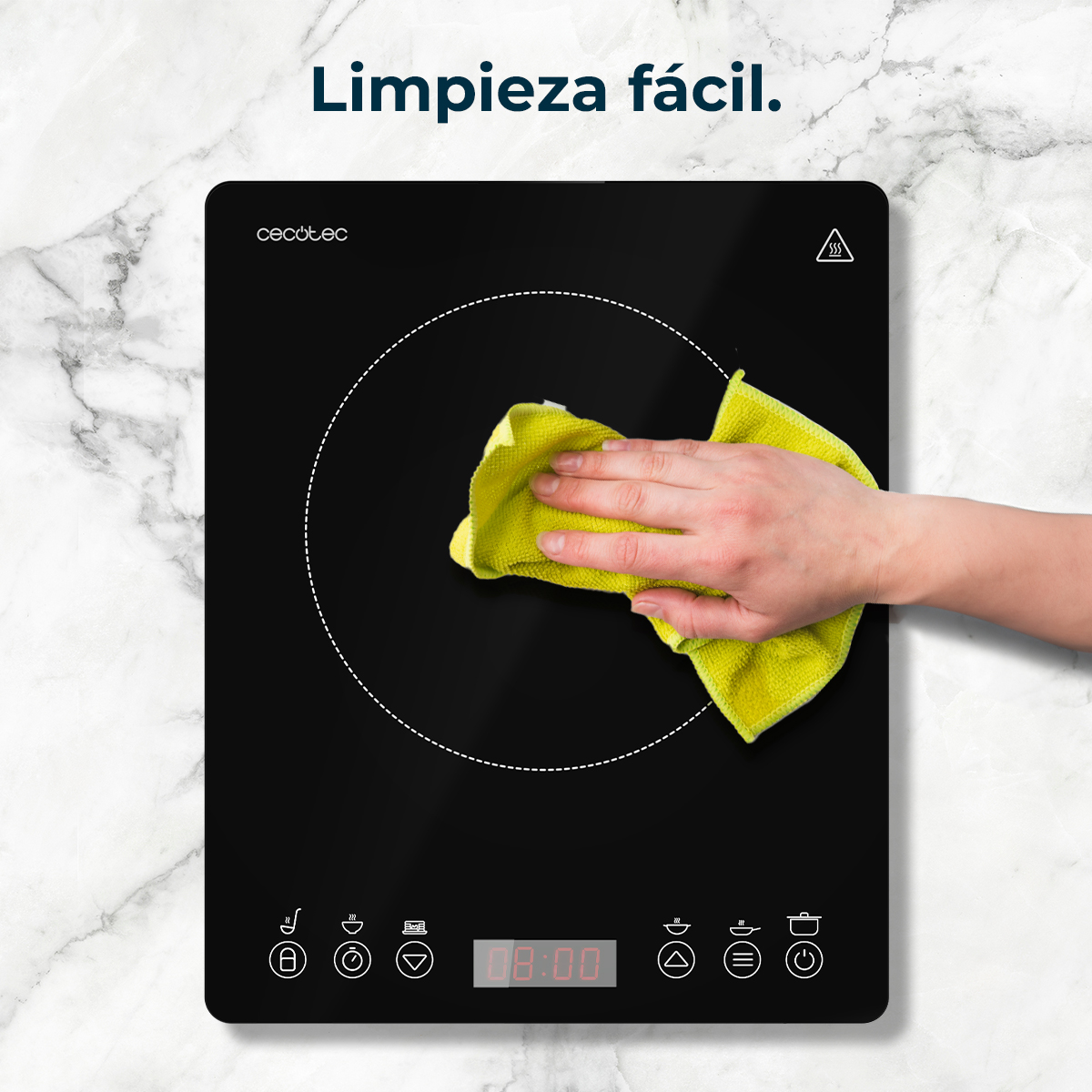 Una mano limpia una placa de inducción negra con un paño amarillo, la hora es 08:00, el texto dice 'Limpieza fácil'.
