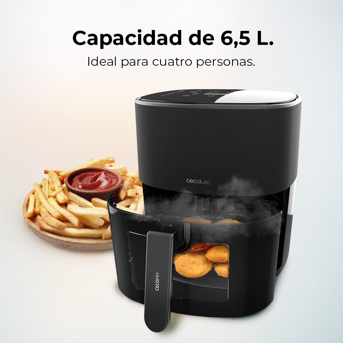 Freidora de aire negra con asa, papas fritas y ketchup a la izquierda. Capacidad 6.5L, ideal para cuatro personas.